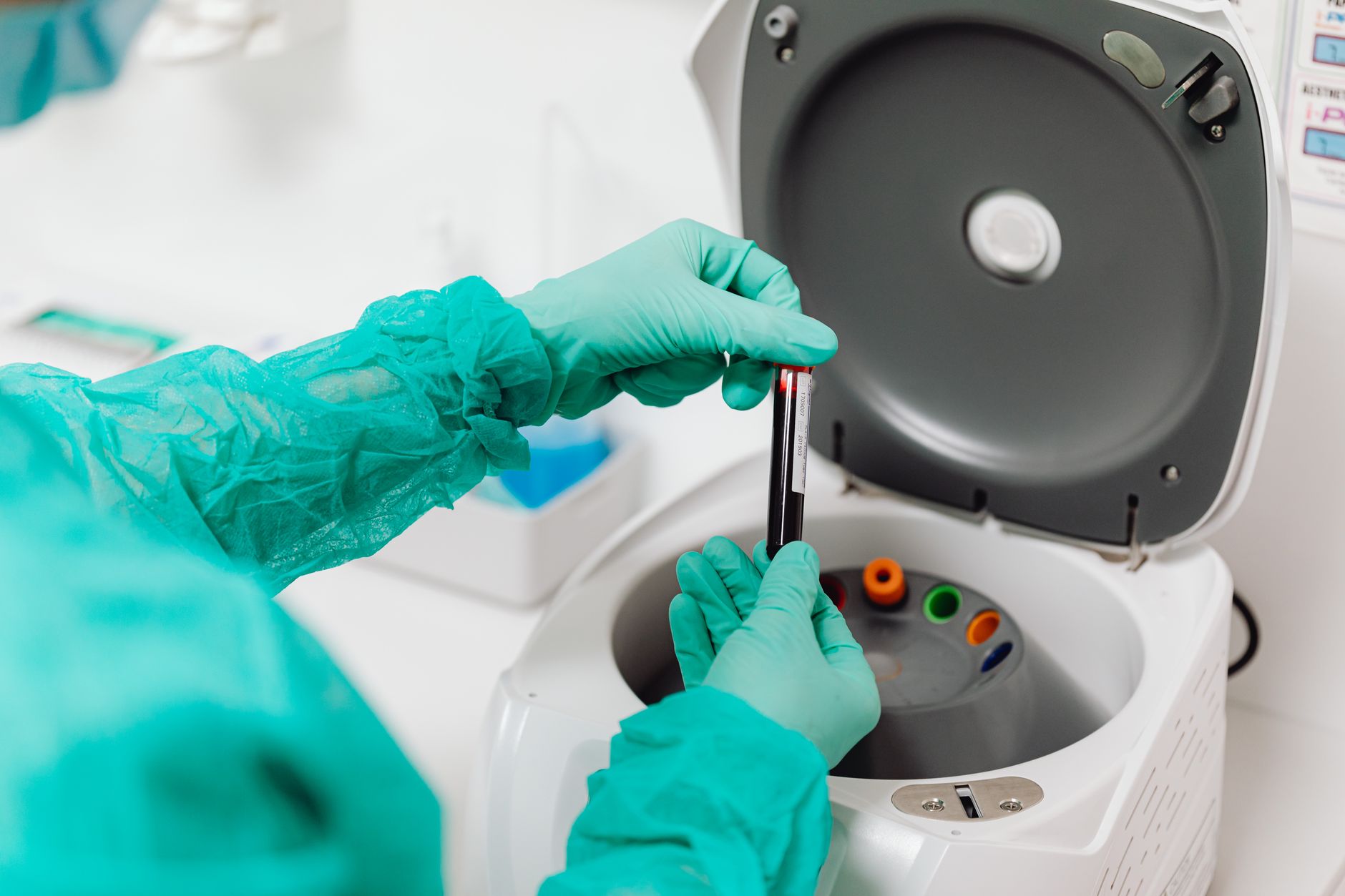a clinical laboratory interior with rows of centrifuge machines and specimen processing equipment under bright overhead lighting