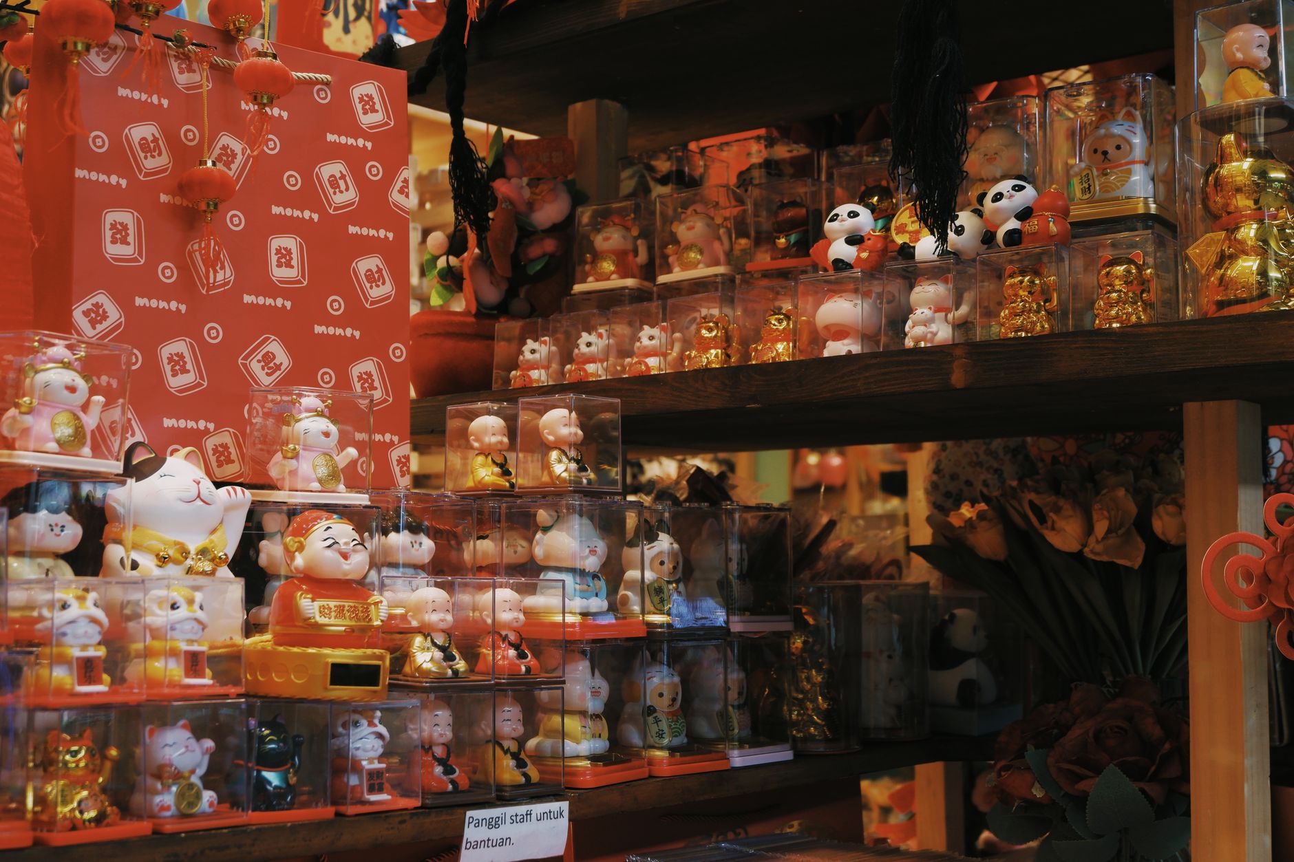 shelves of unpainted resin miniature figurines displayed inside a specialist hobby retail store, lit by warm overhead lighting