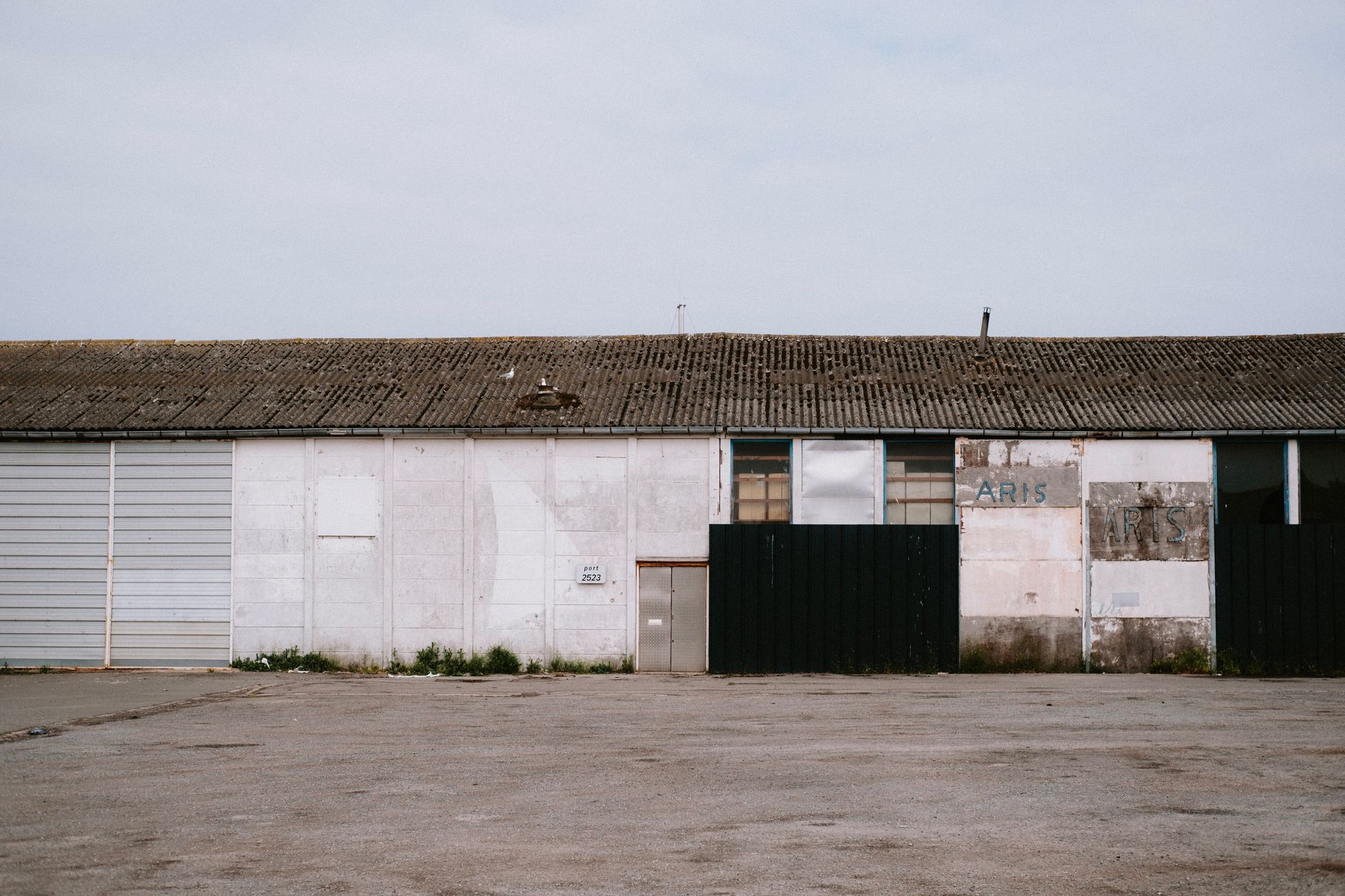 exterior of a large red-brick manufacturing and distribution facility in an English Midlands industrial estate, photographed on an overcast morning