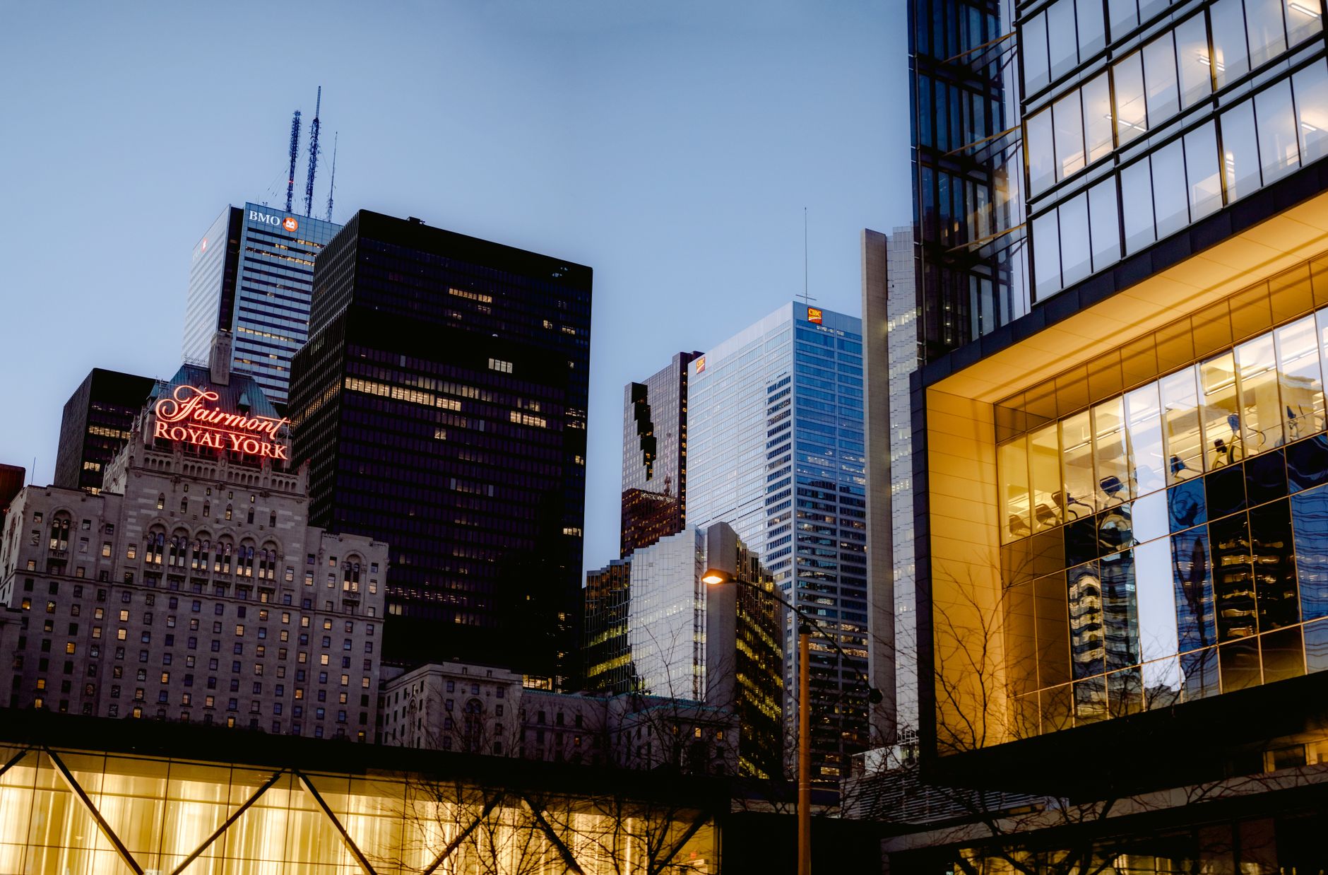 exterior of the Goldman Sachs headquarters building in lower Manhattan at dusk, with city lights reflected on glass facades