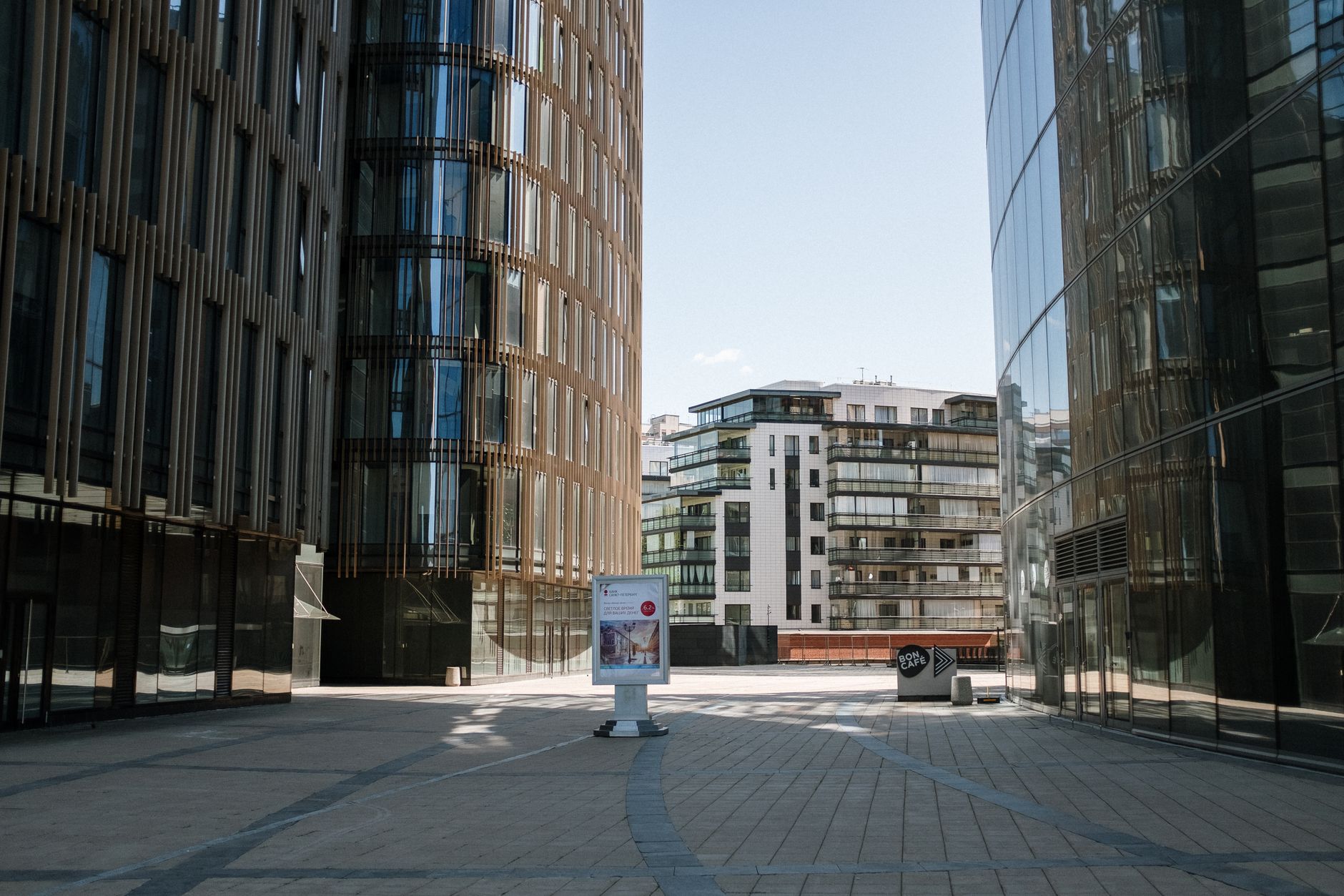 exterior of a modern glass-fronted technology office building in an urban setting during daylight, with a wide pavement in the foreground