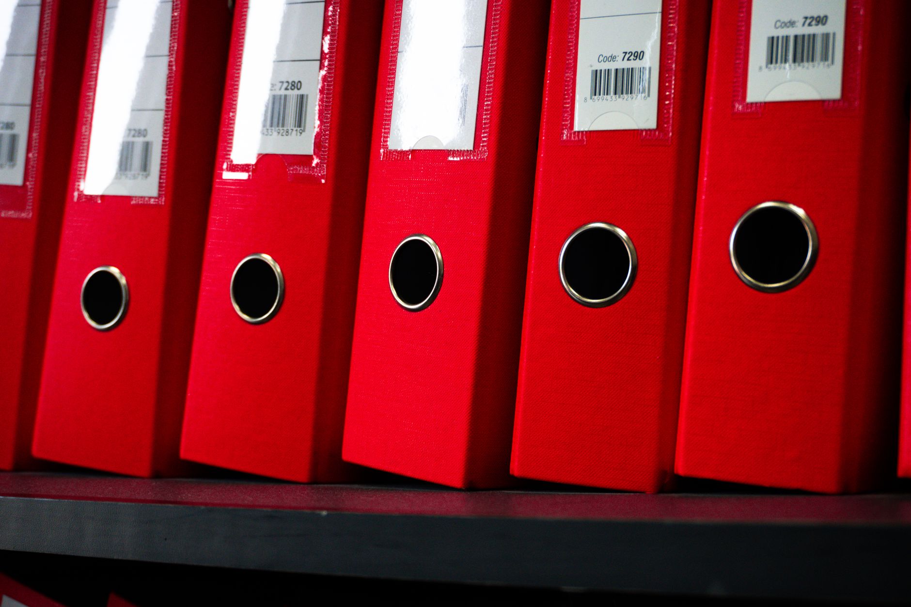 rows of patent filing documents and legal binders stacked on shelves inside a law library with tall wooden cases