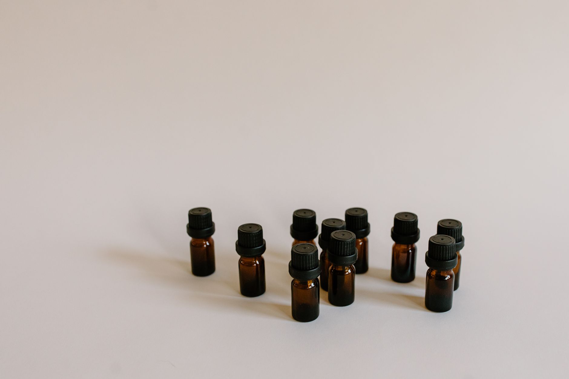 close-up of small-batch lavender essential oil glass bottles arranged on a rustic wooden market stall surface, no labels visible