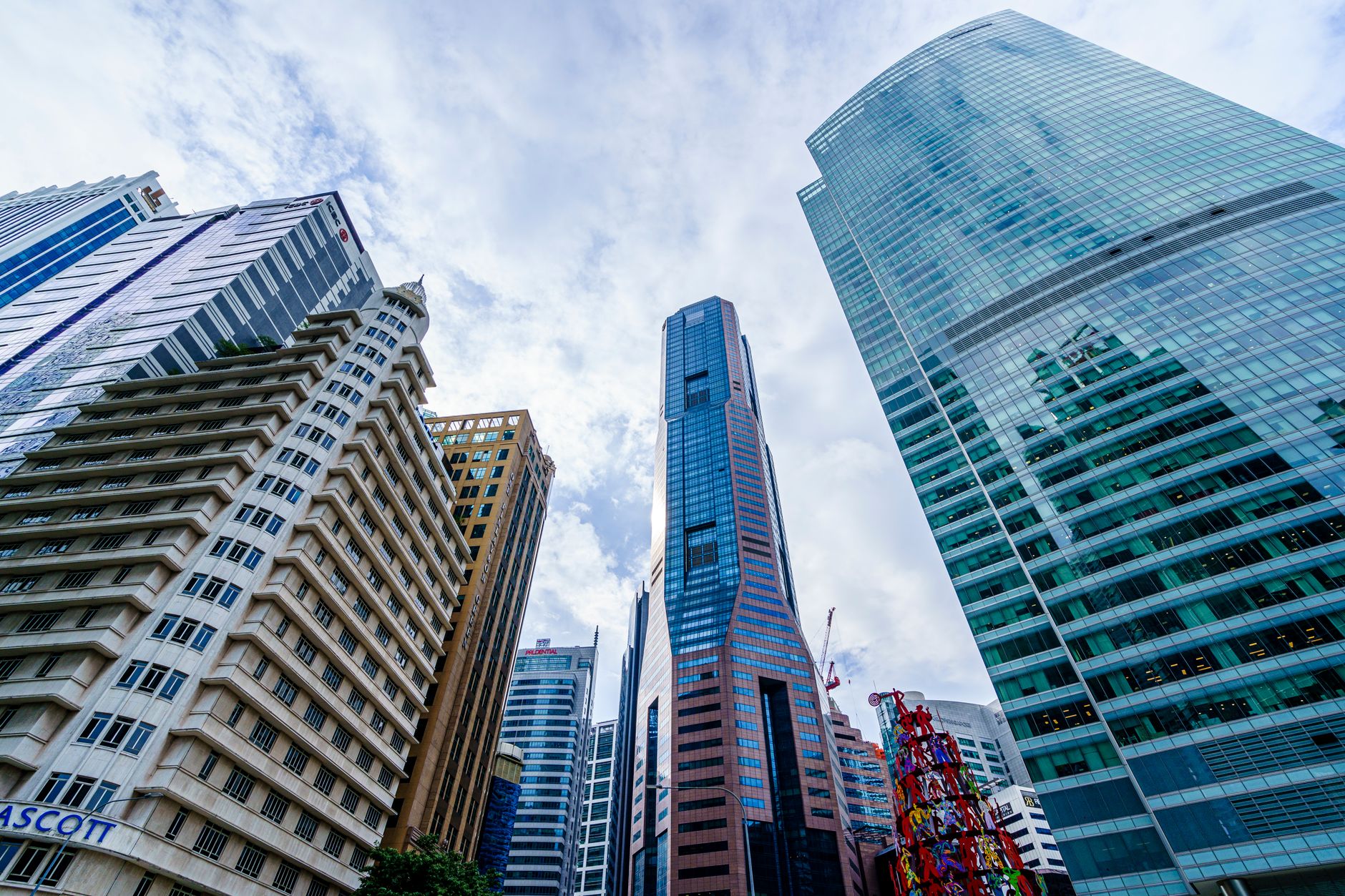 exterior of the Monetary Authority of Singapore headquarters building on Shenton Way, glass facade reflecting Singapore's financial district skyline at midday