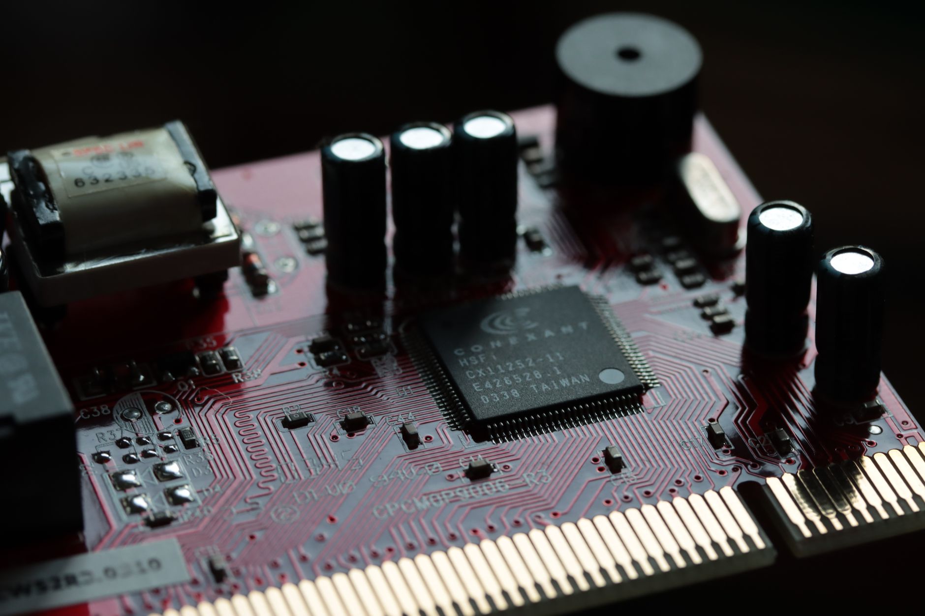 close-up of a circuit board populated with compact AI inference chips and heat sinks, photographed under blue-tinted laboratory lighting