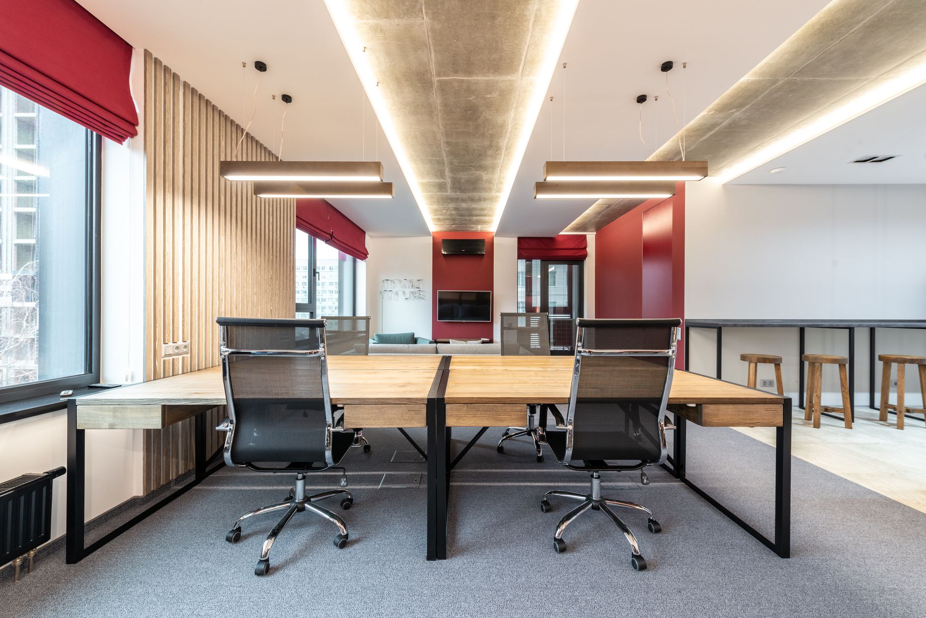 rows of empty office workstations in a modern open-plan technology office with screens powered down and ergonomic chairs neatly tucked in