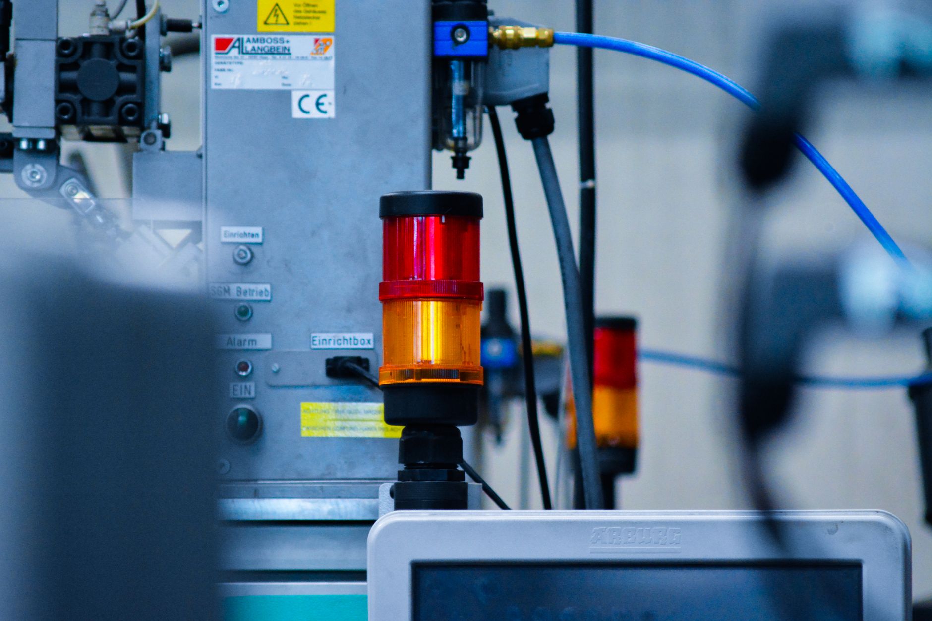 close-up of a semiconductor wafer testing machine inside a cleanroom facility, yellow safety lighting visible overhead