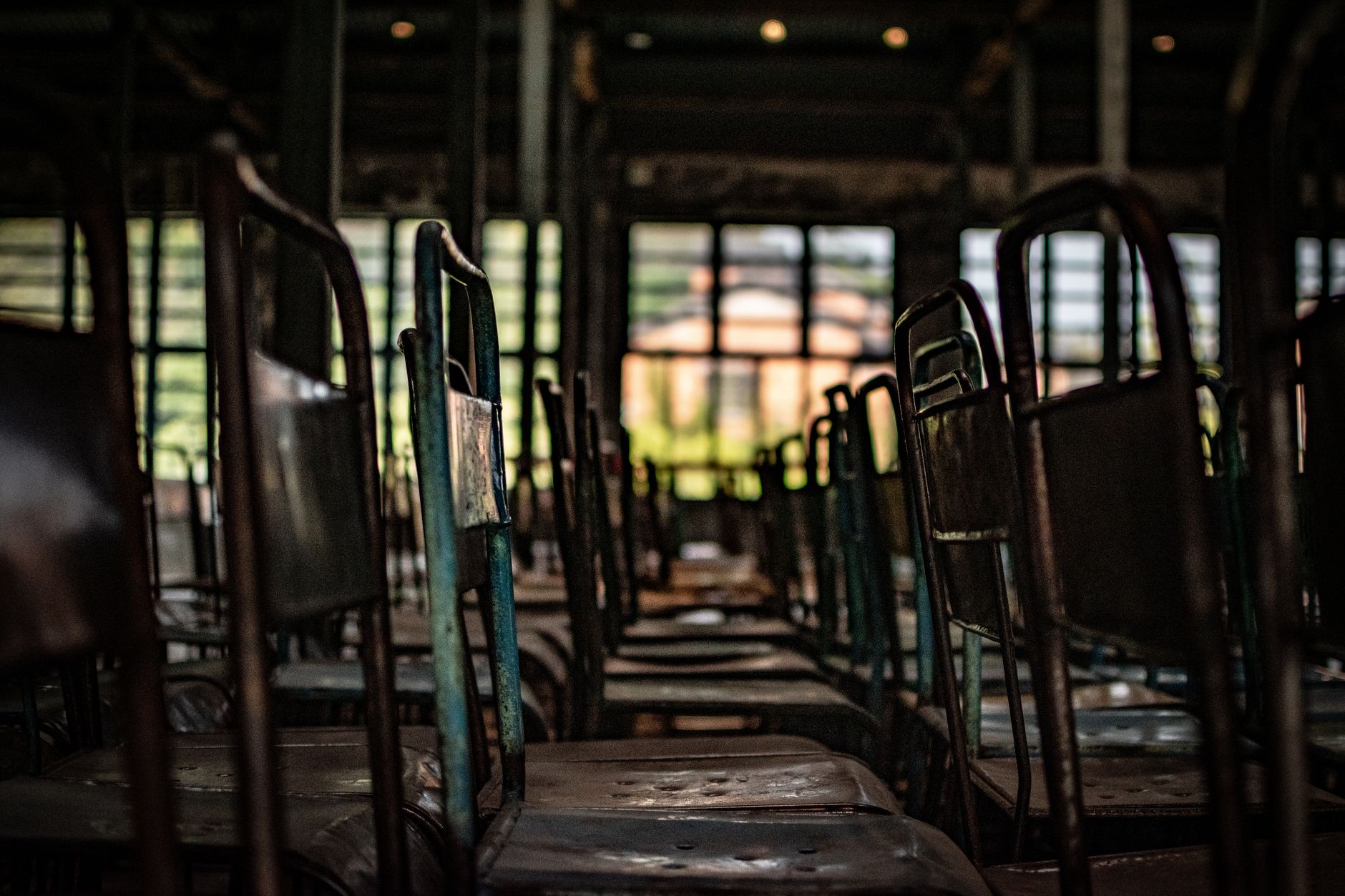 rows of steel coils stacked in a dimly lit industrial warehouse, rust visible on the edges of older stock