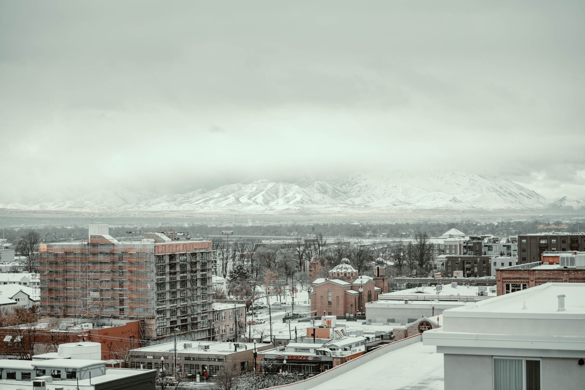 aerial view of Salt Lake City's downtown skyline with the Wasatch mountain range in the background on a clear day