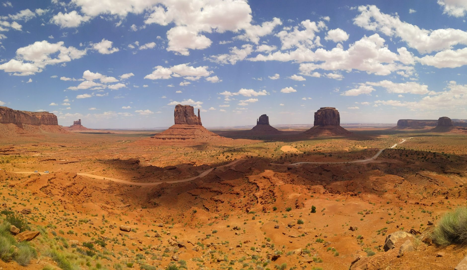 a newly constructed highway interchange near a Utah desert plateau with red rock formations visible in the distance