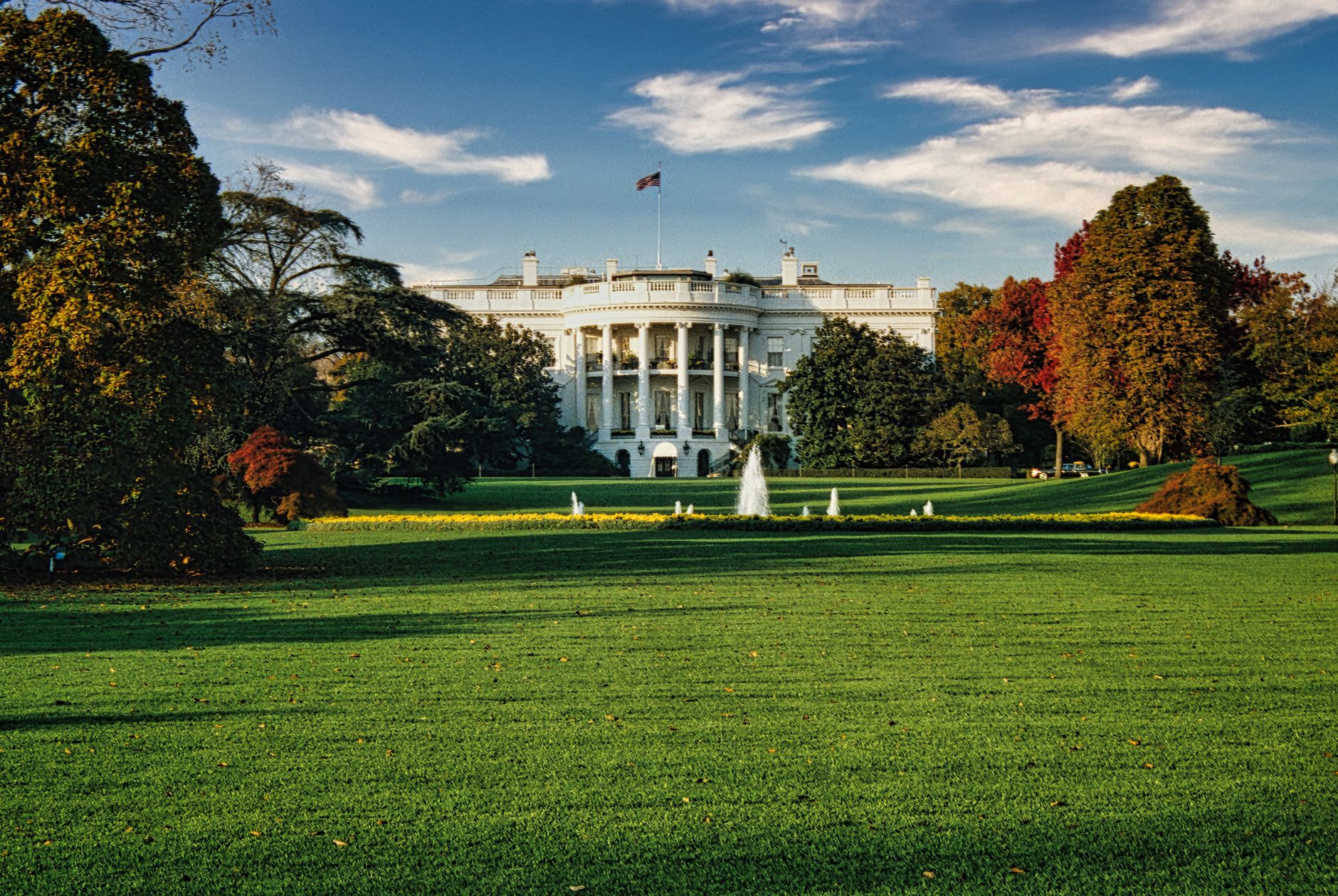 wide-angle view of the Eisenhower Executive Office Building exterior on a clear morning, with the Treasury Department flag visible in the foreground