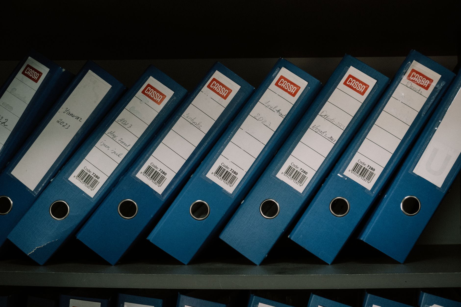rows of U.S. Treasury bond certificates displayed in an archival storage case inside a government facility