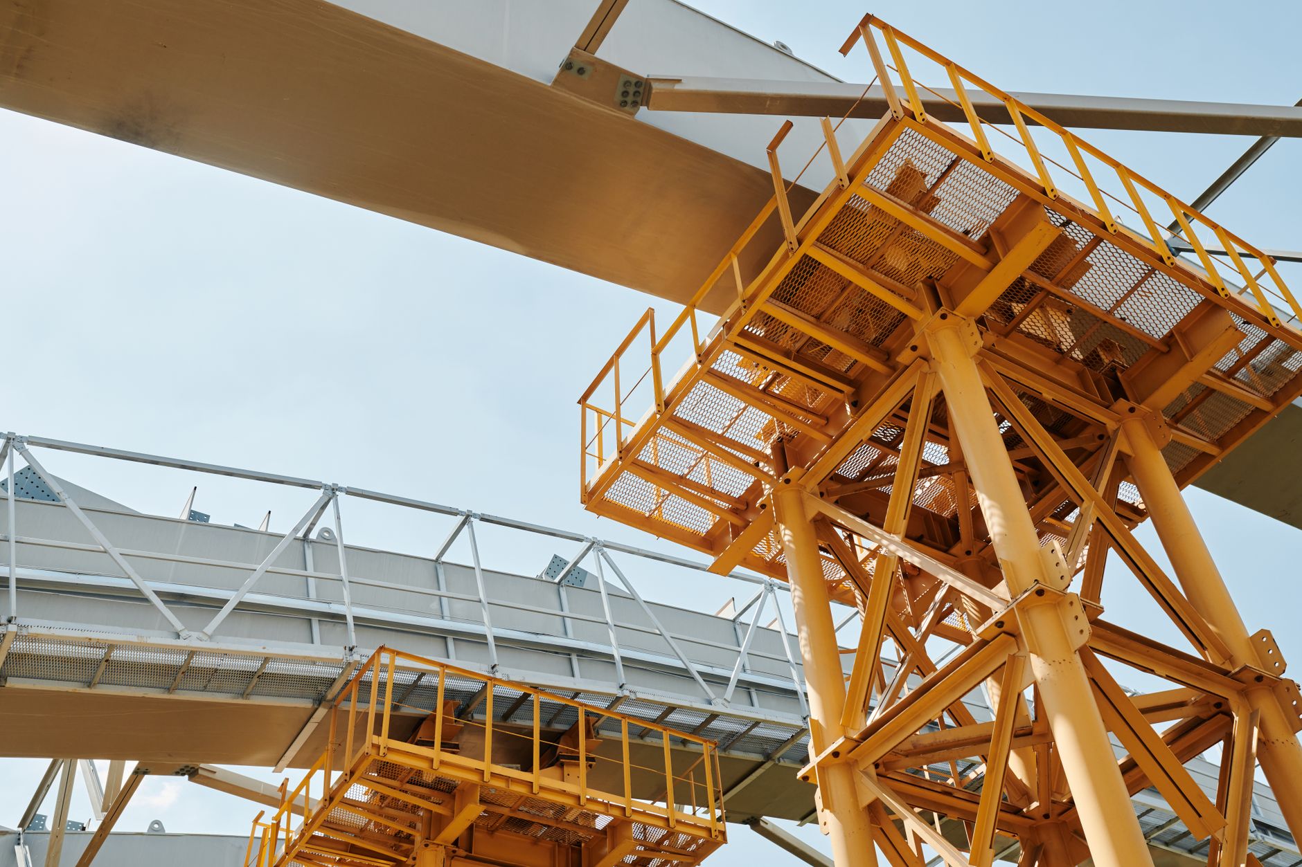 wide exterior shot of a large rocket assembly facility at dusk, industrial scaffolding and launch infrastructure visible against an orange sky