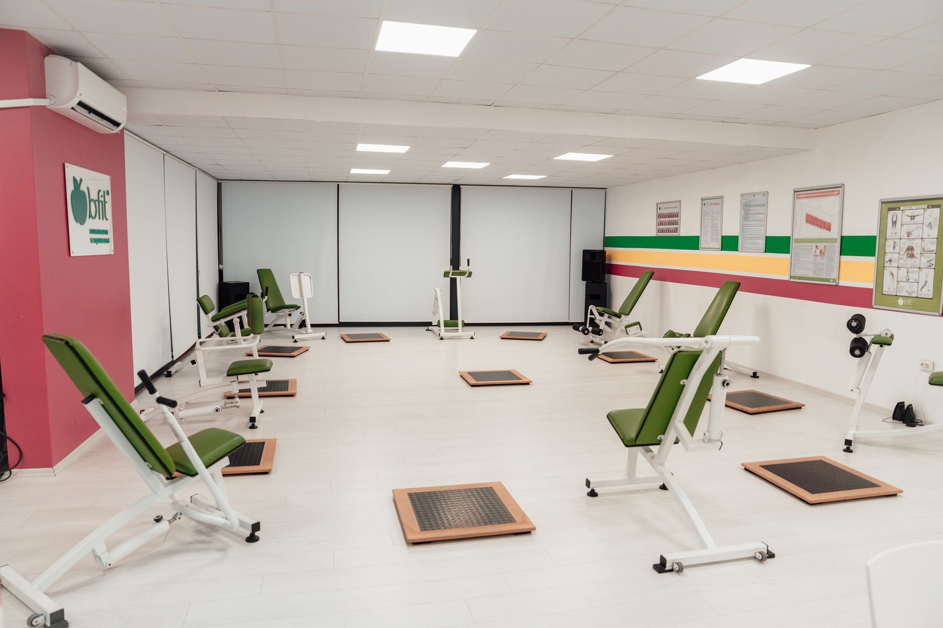 interior of a modern university athletic training facility showing rows of specialized equipment, recovery pods, and digital performance tracking screens along the walls