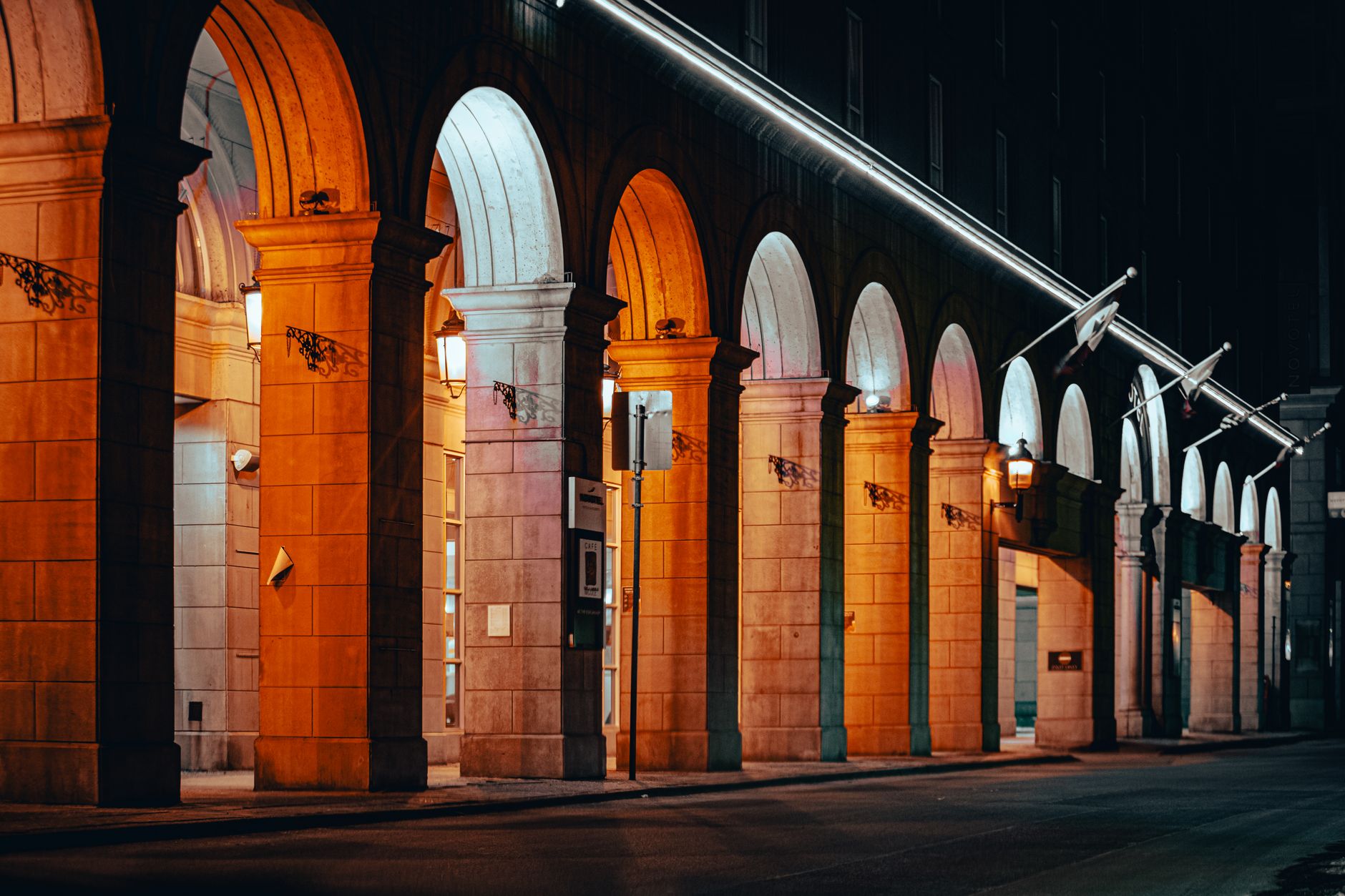 exterior of a neoclassical financial regulatory building at dusk, its stone facade lit by street lamps, with revolving doors and bronze signage visible in the foreground