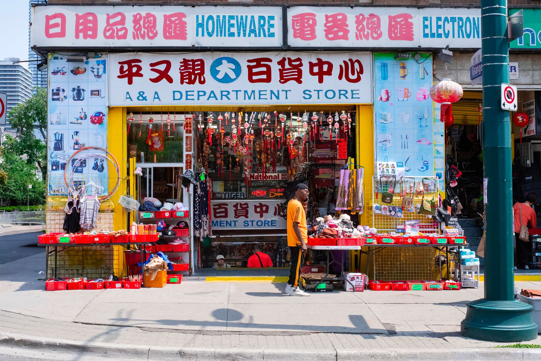 Exterior of a large Chinese consumer electronics and appliance retail store at street level in an urban district, with promotional sale banners visible in the shop windows