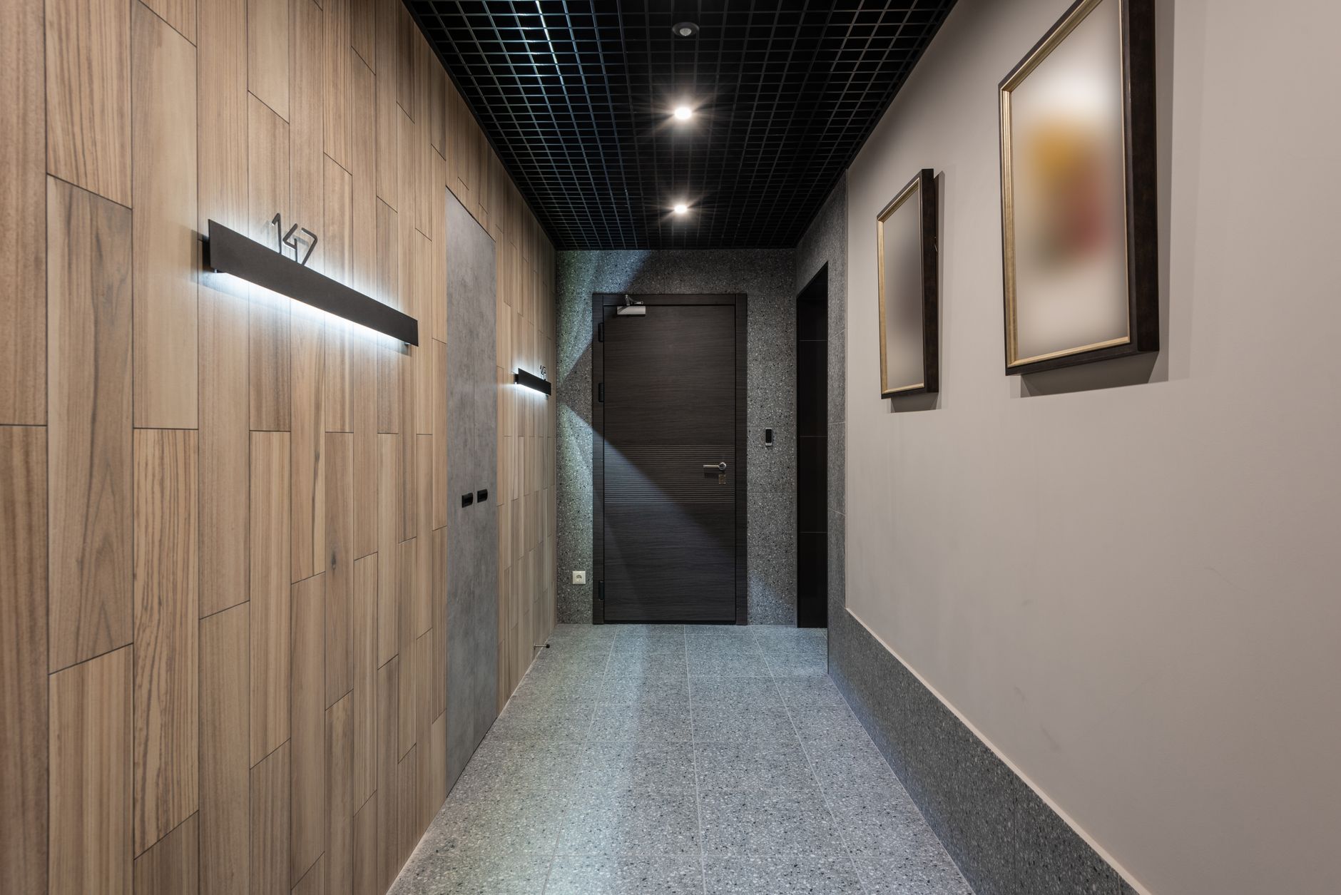 rows of identical extended-stay hotel room doors along an exterior corridor, with maintenance equipment parked near the entrance