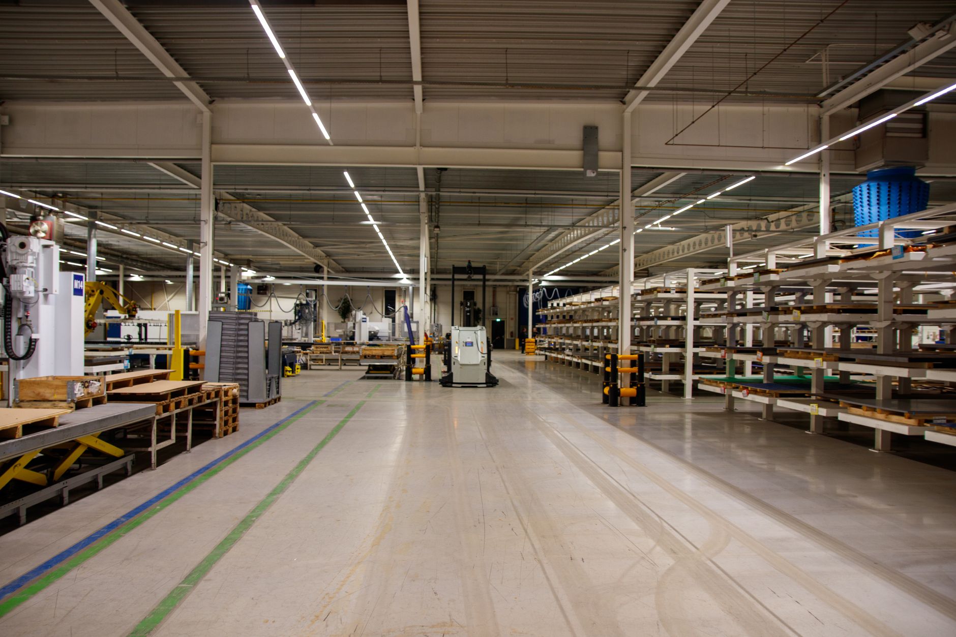 rows of silicon wafers on a cleanroom storage rack inside a chip fabrication facility, lit by yellow overhead lighting