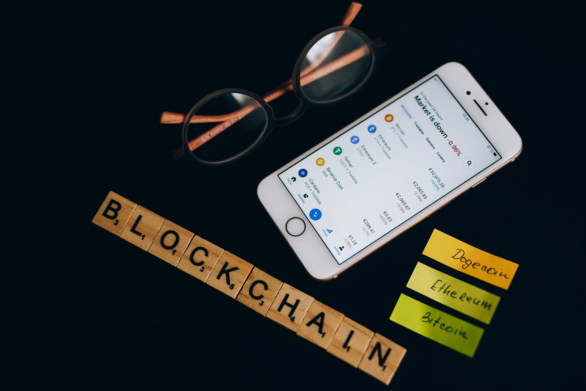 close-up of a hardware cryptocurrency cold wallet device resting on a dark desk beside a legal document and pen