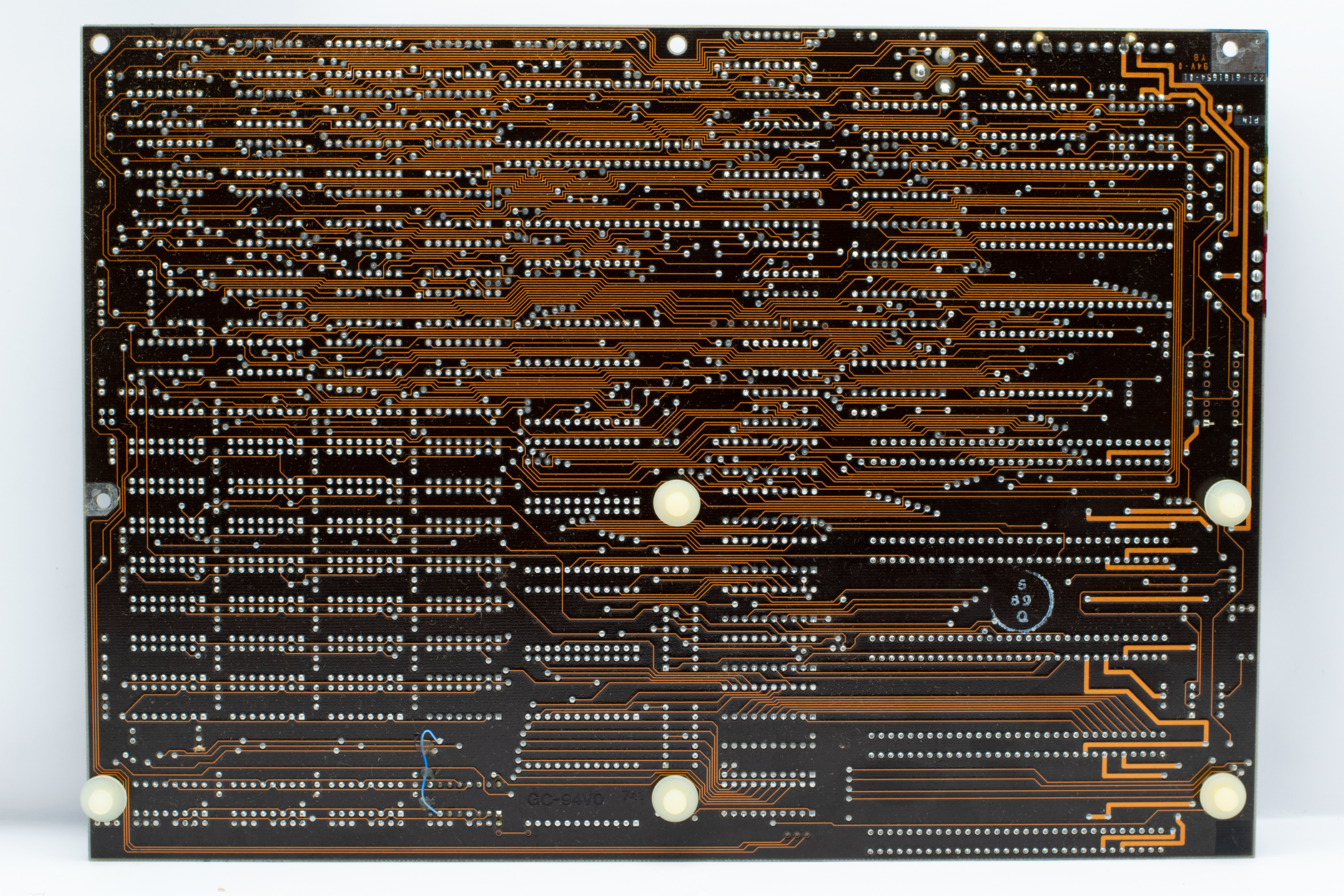 close-up of a multilayer printed circuit board with fine copper trace patterns under bright white manufacturing lighting