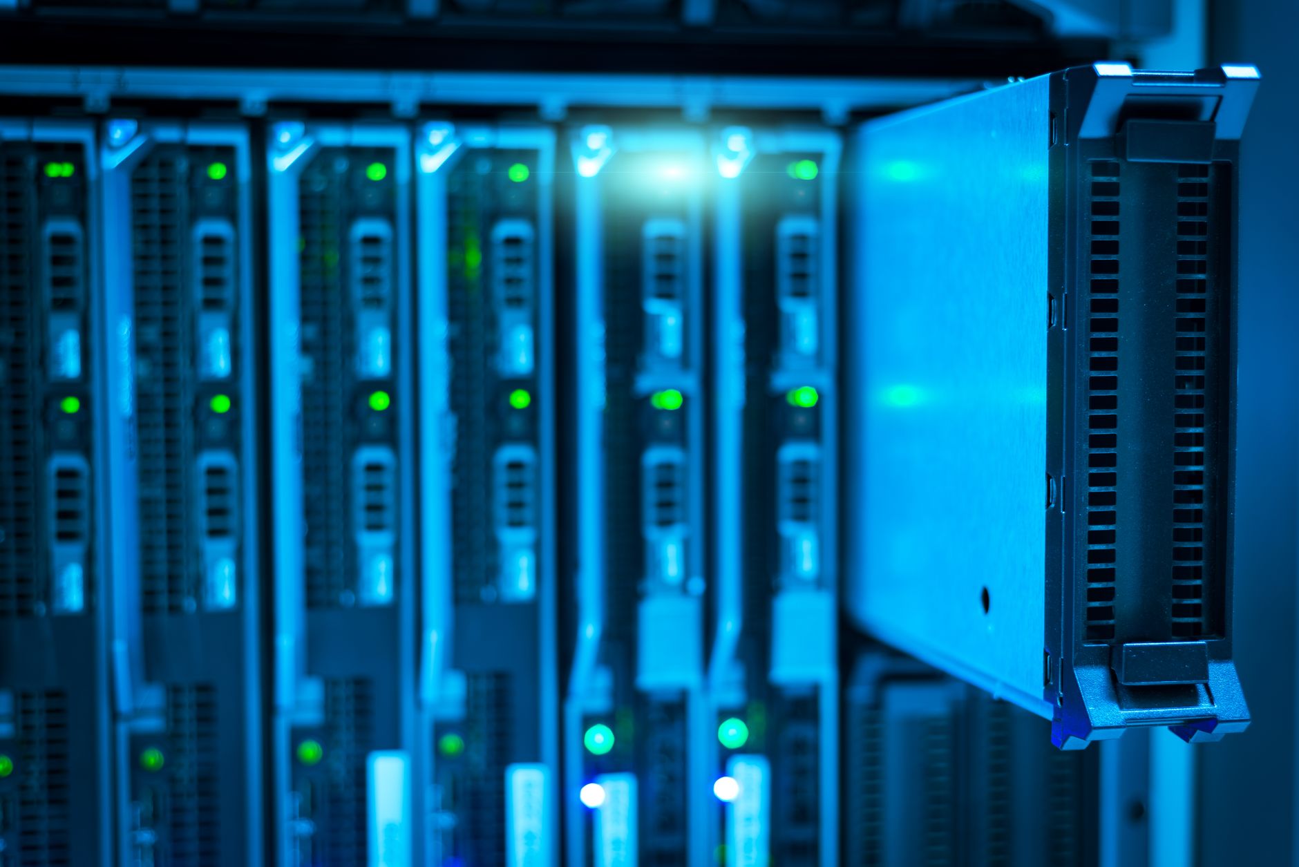 rows of server racks inside a modern data center facility with blue indicator lights and raised floor cooling vents visible