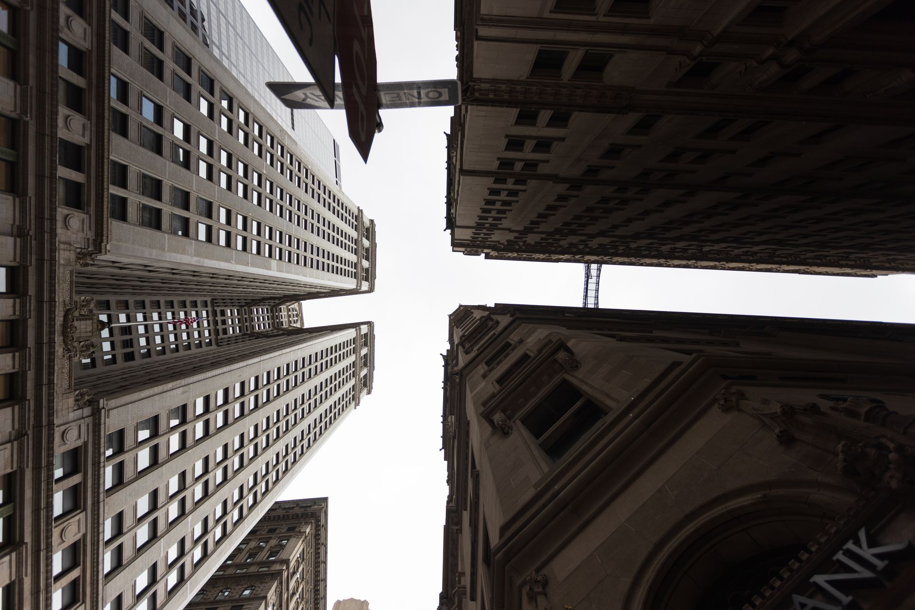 rows of Federal Reserve district bank buildings viewed from street level on an overcast morning, architectural detail visible on stone facades