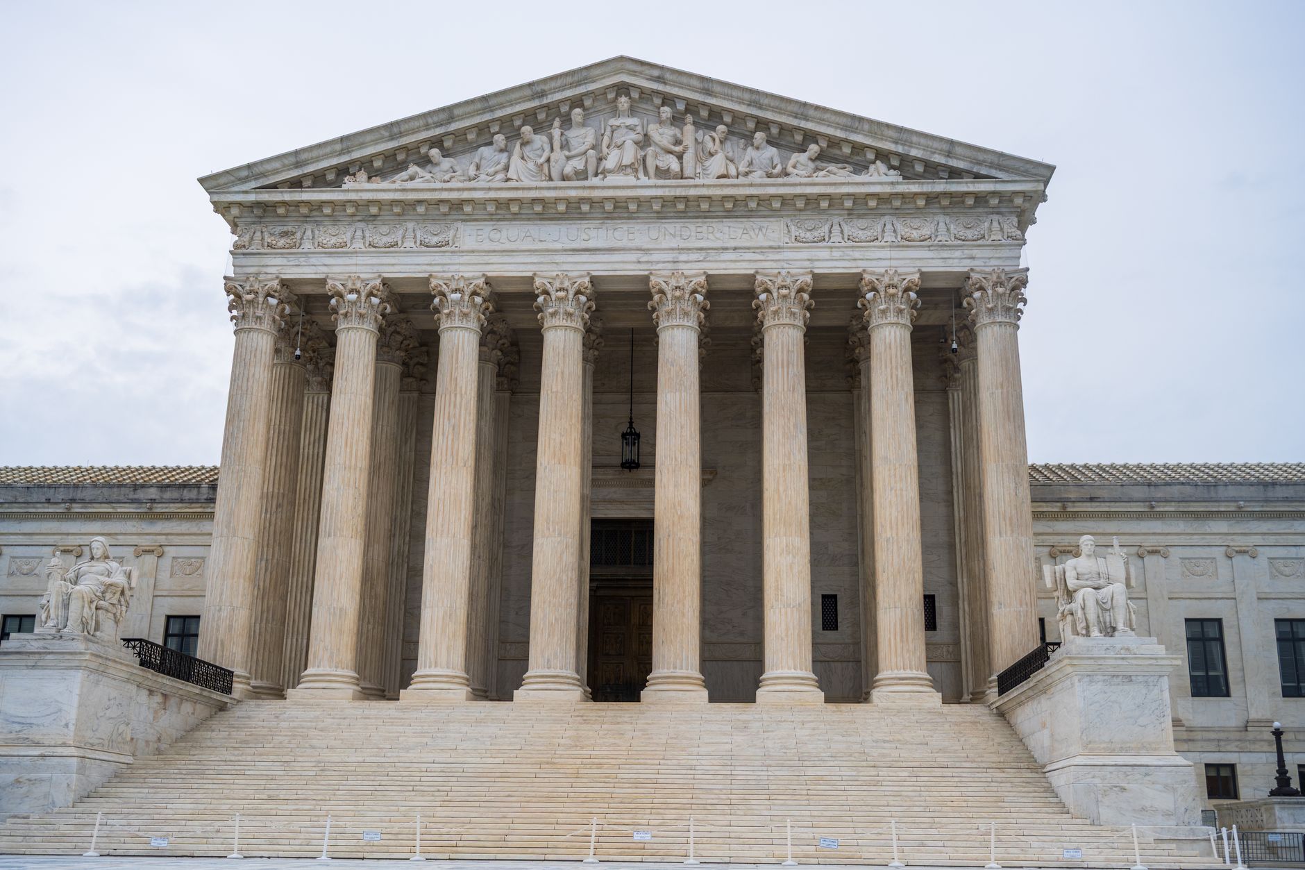 exterior of the Marriner S. Eccles Federal Reserve Board building in Washington at midday, classical limestone columns and the broad stone steps in sharp focus