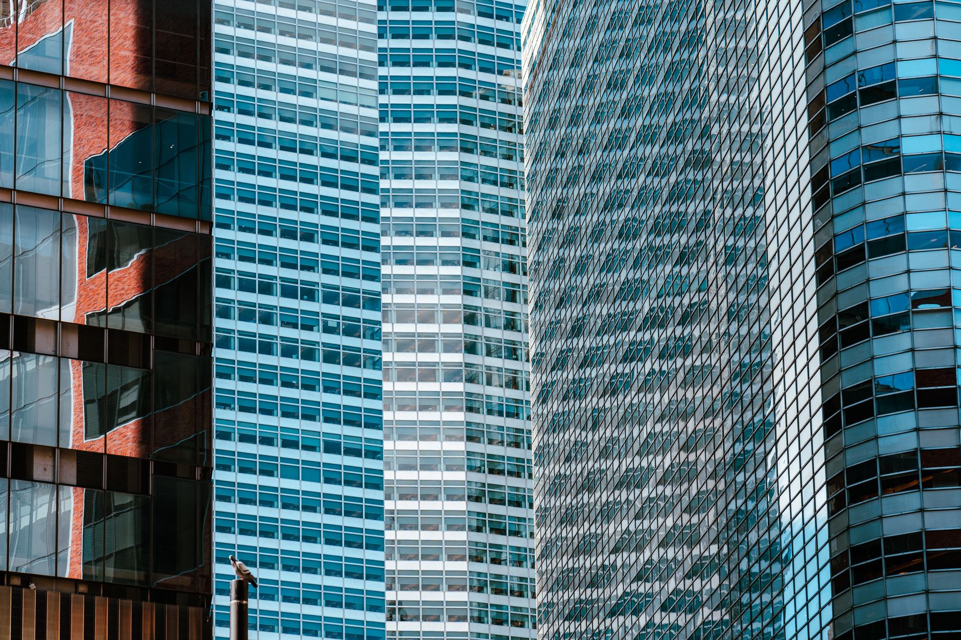 exterior of a glass-fronted financial technology office building on a Manhattan street corner, late afternoon light reflecting off the facade