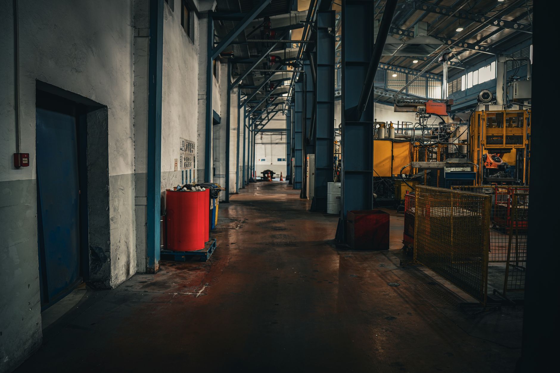 rows of unfinished industrial machinery components staged on a factory floor under fluorescent lighting inside a German manufacturing plant