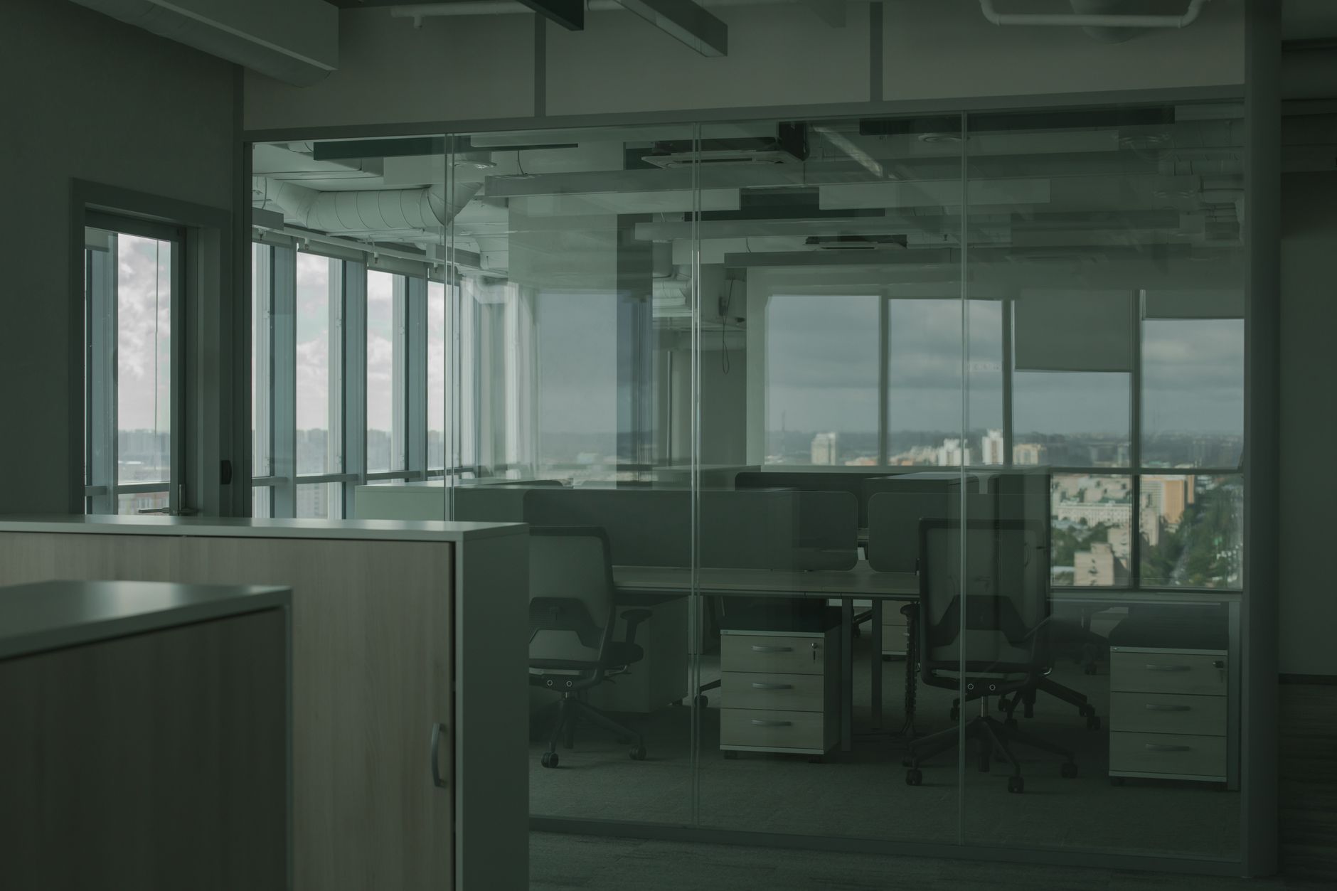 rows of empty conference tables inside a corporate services office building in Berlin, with natural light filtering through large windows