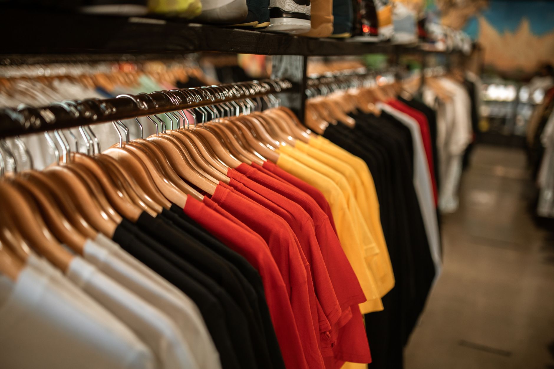 rows of blank white activewear garments hanging on industrial racks inside a warehouse distribution centre