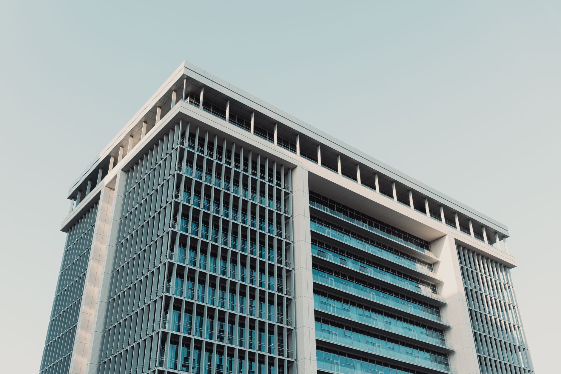 glass-and-steel office building in a modern Tel Aviv technology district, viewed from street level at midday