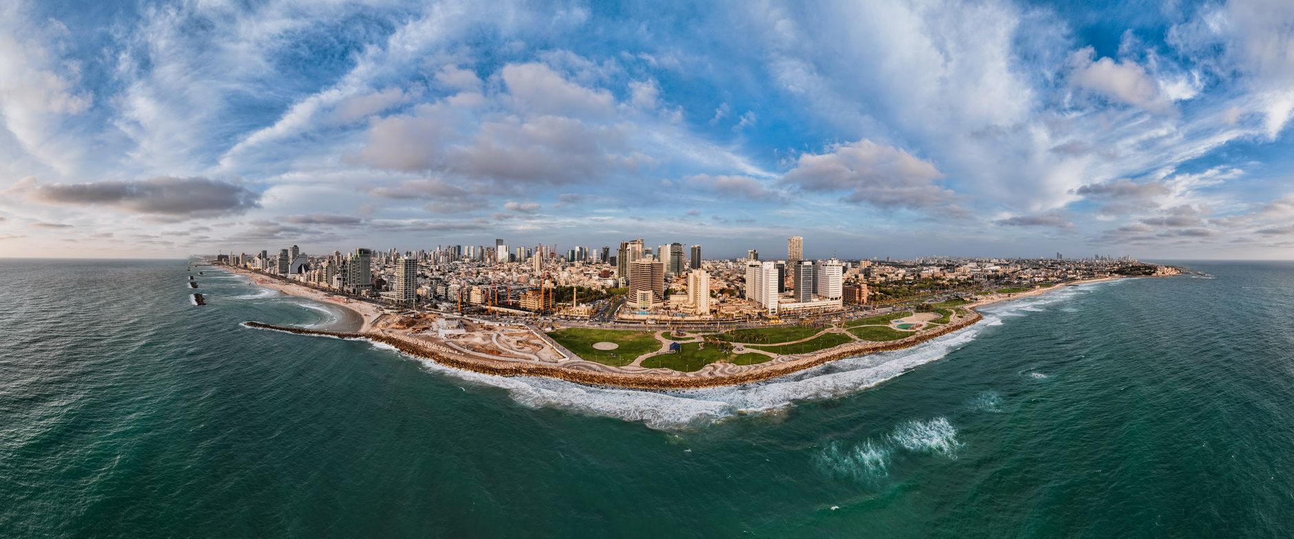 aerial view of the Tel Aviv skyline at midday with modern office towers and construction cranes visible against a clear sky