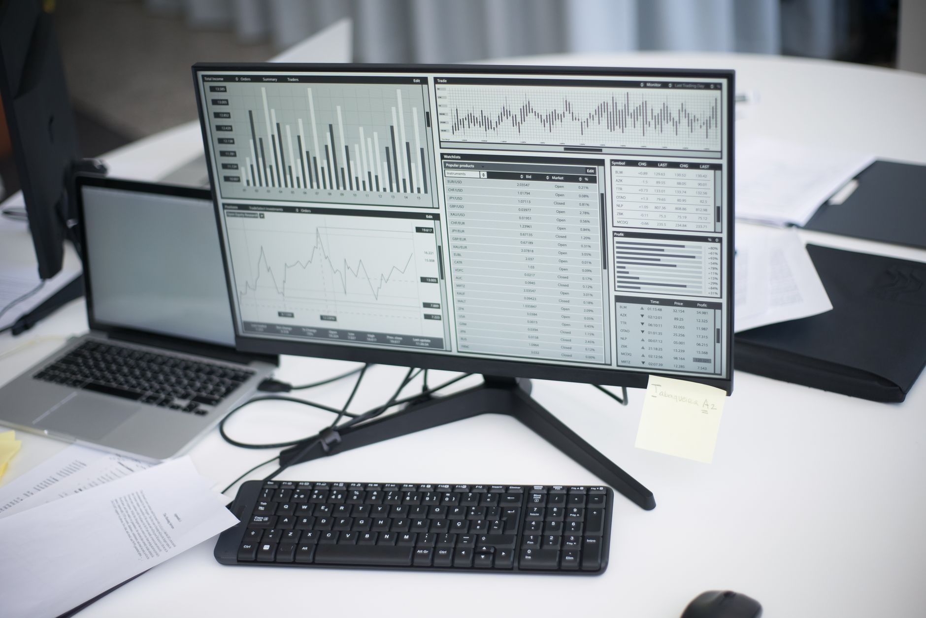 interior of a modern financial technology office with multiple workstations displaying bond yield curves and trading dashboards