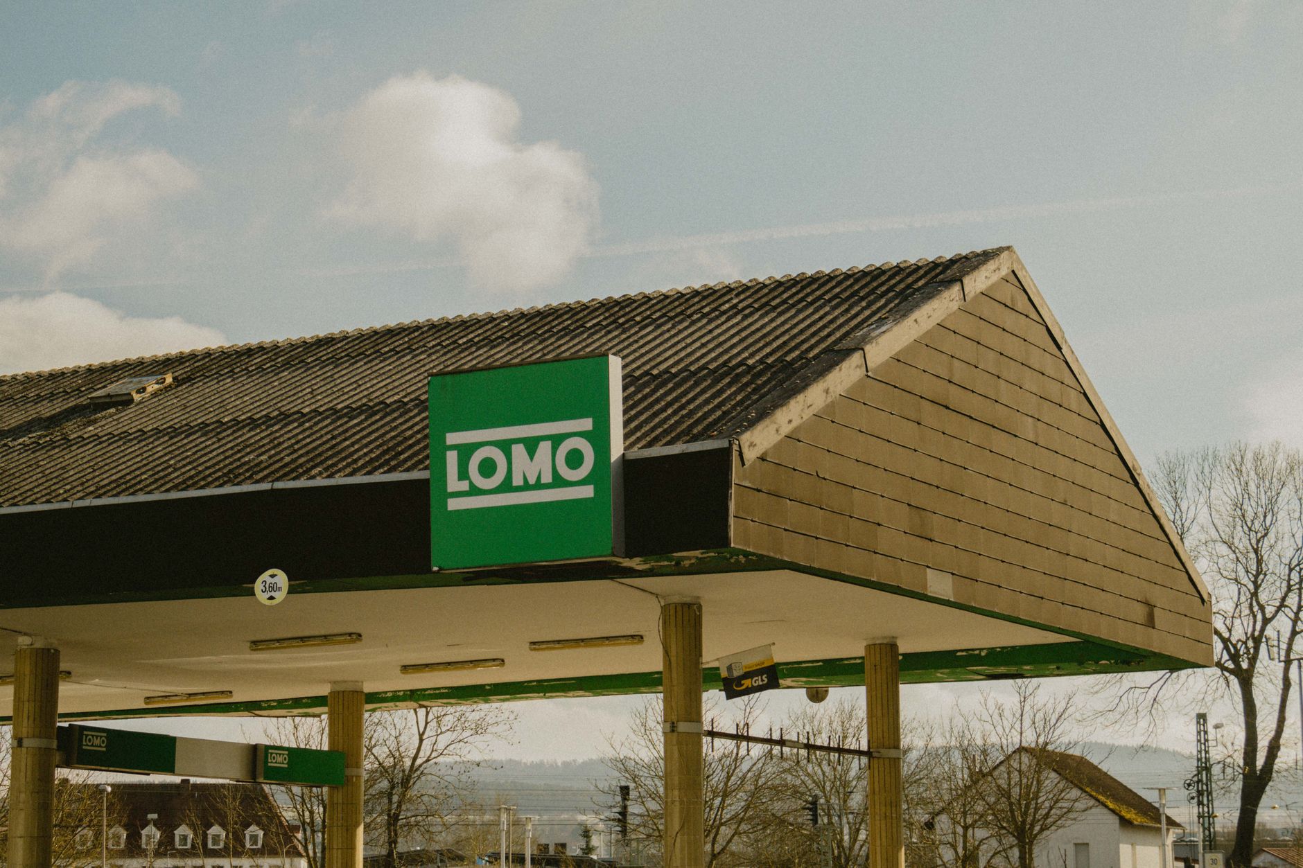 exterior of a suburban mortgage lending office building with a roadside sign displaying interest rate figures, overcast sky above