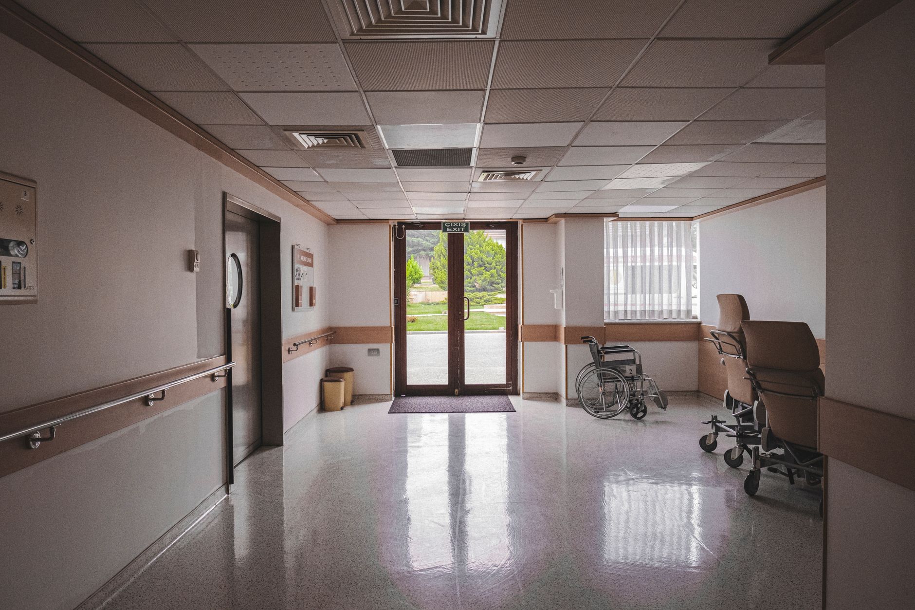 interior corridor of a small freestanding emergency hospital facility with medical equipment visible along the walls and overhead lighting illuminating an empty hallway