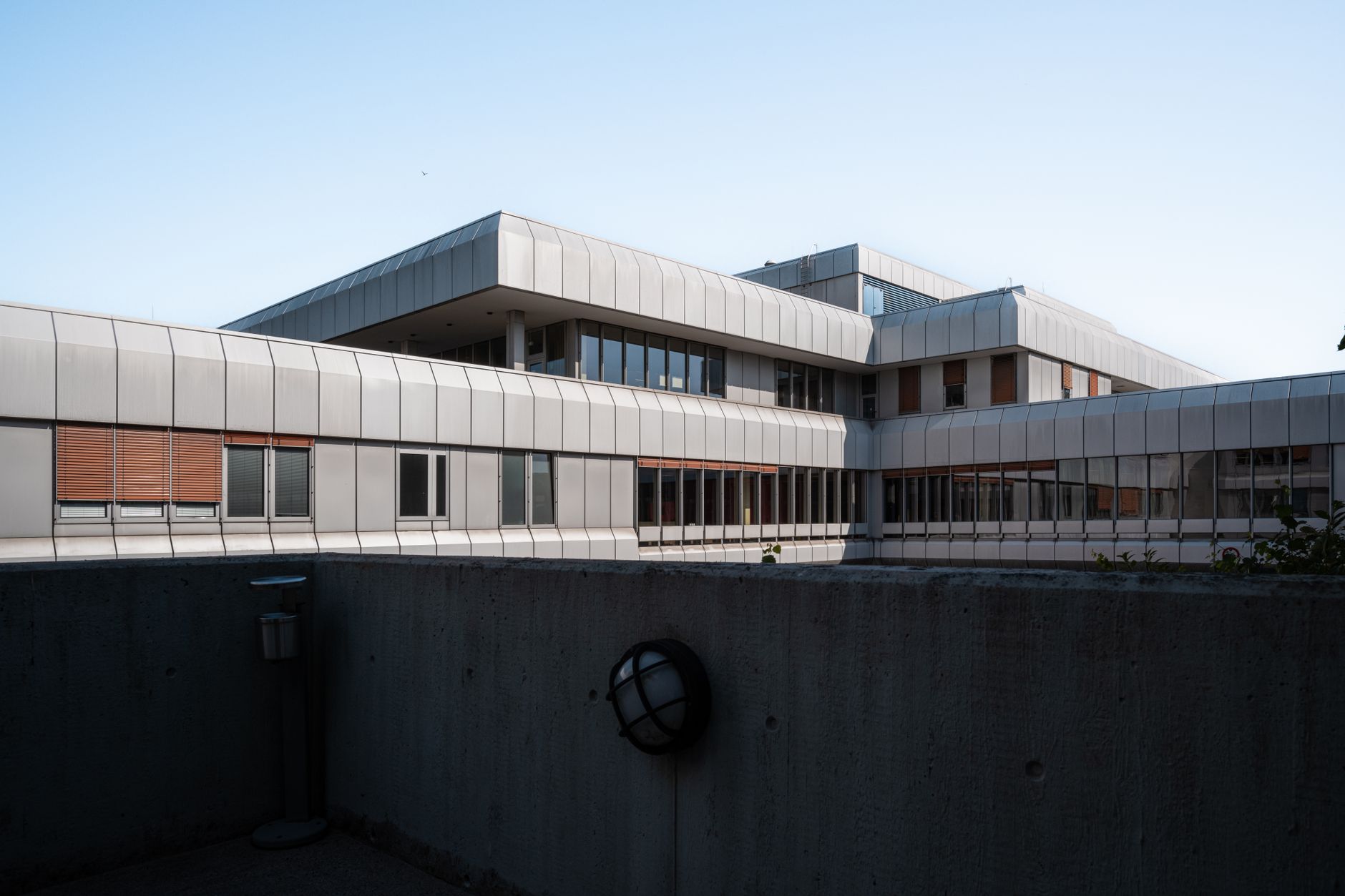 exterior of a modern pharmaceutical research facility surrounded by landscaped grounds under clear daylight