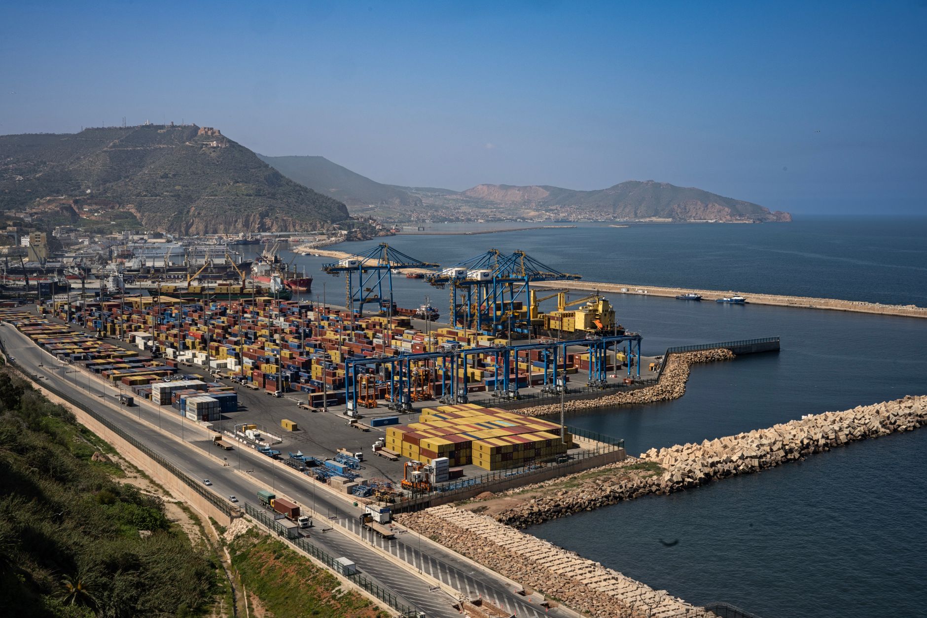 aerial view of container ships queued near the Bab el-Mandeb strait entrance, with arid coastline and open ocean visible from above