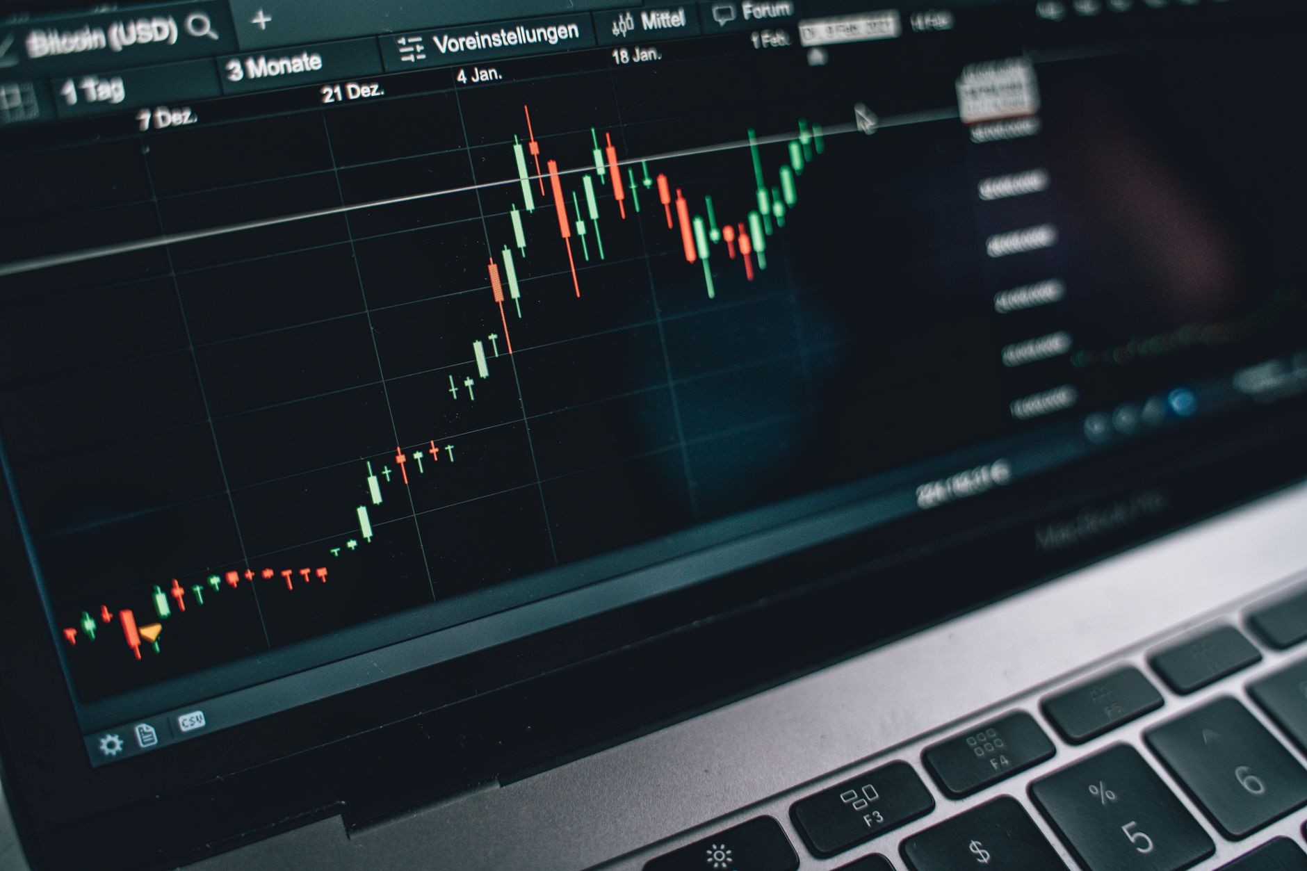 rows of computer monitors displaying cryptocurrency price charts and trading data in a dimly lit financial operations room