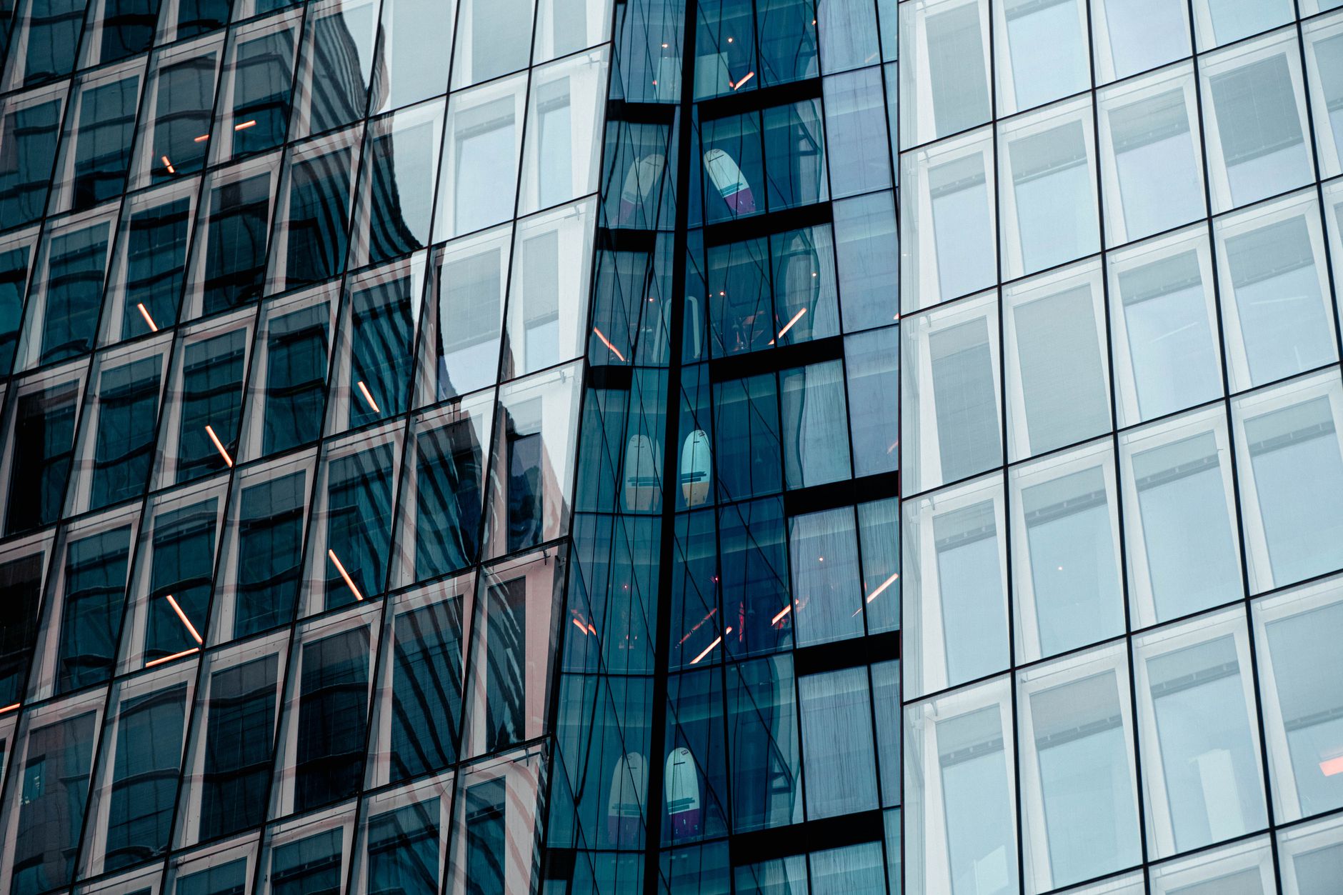 exterior of a modern Tel Aviv technology campus at dusk, glass-fronted office buildings reflecting city lights