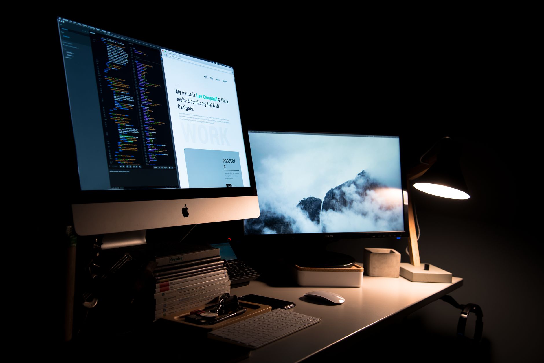 interior of a modern software development office with rows of monitors displaying lines of code in a dimly lit open-plan workspace