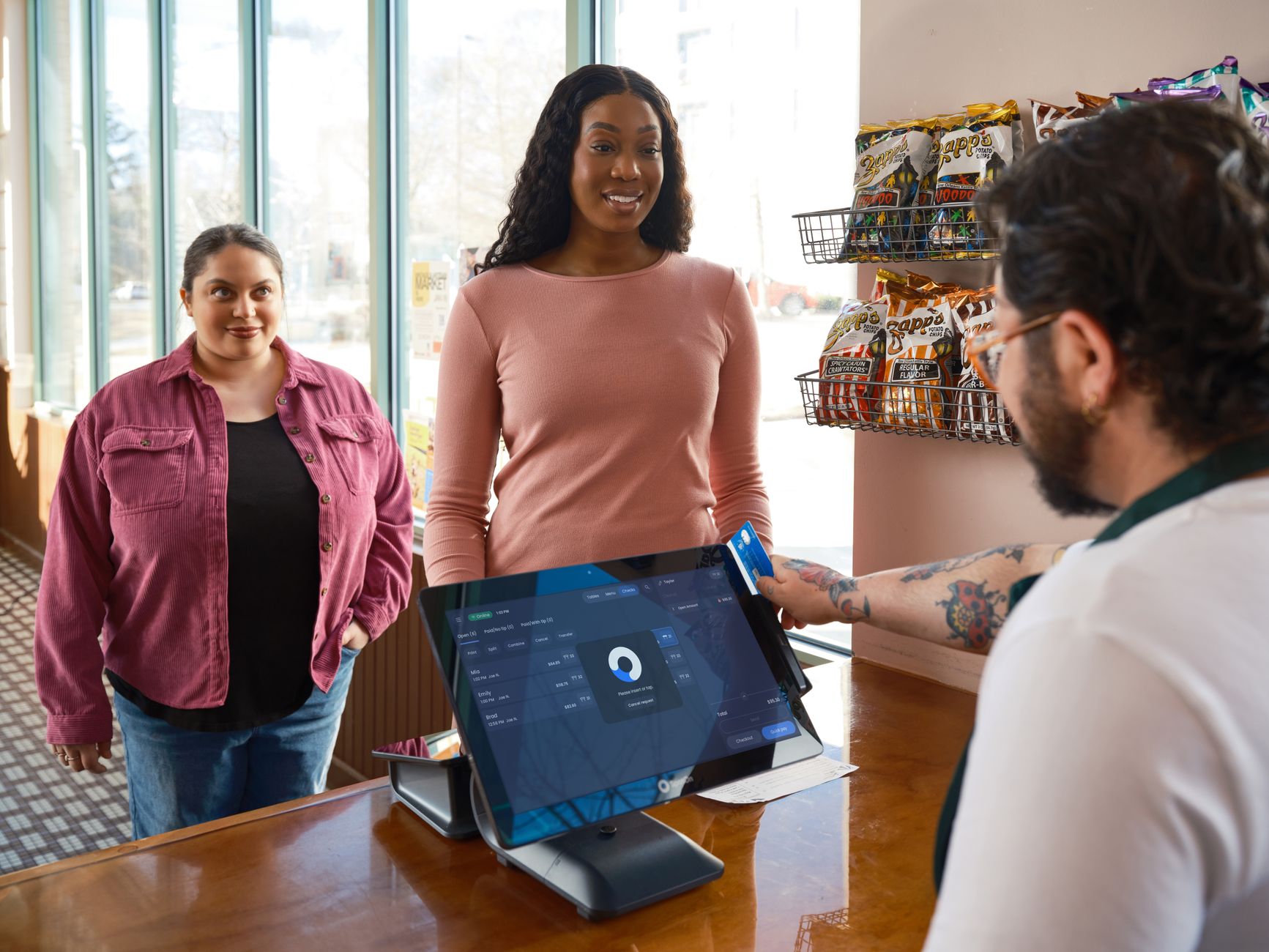 a row of point-of-sale terminals in a modern retail environment displaying digital payment options on their screens