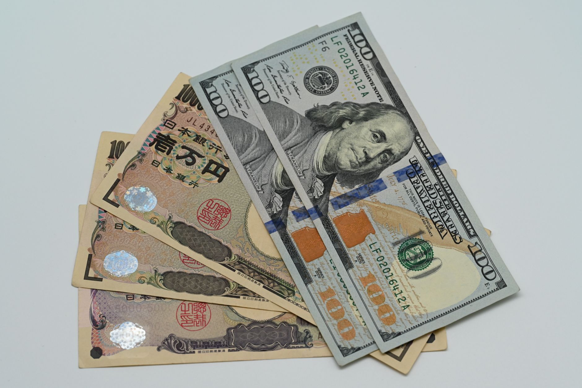 rows of currency trading terminals displaying yen and dollar exchange rate feeds in a dimly lit dealing room, no visible faces