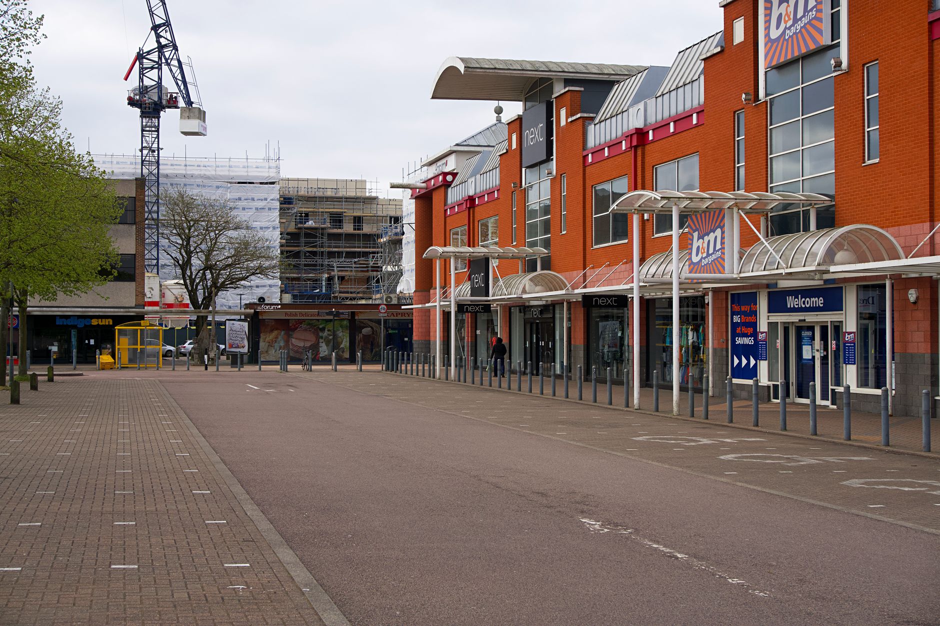rows of empty commercial properties on a quiet urban high street with visible lease signs in darkened shopfront windows