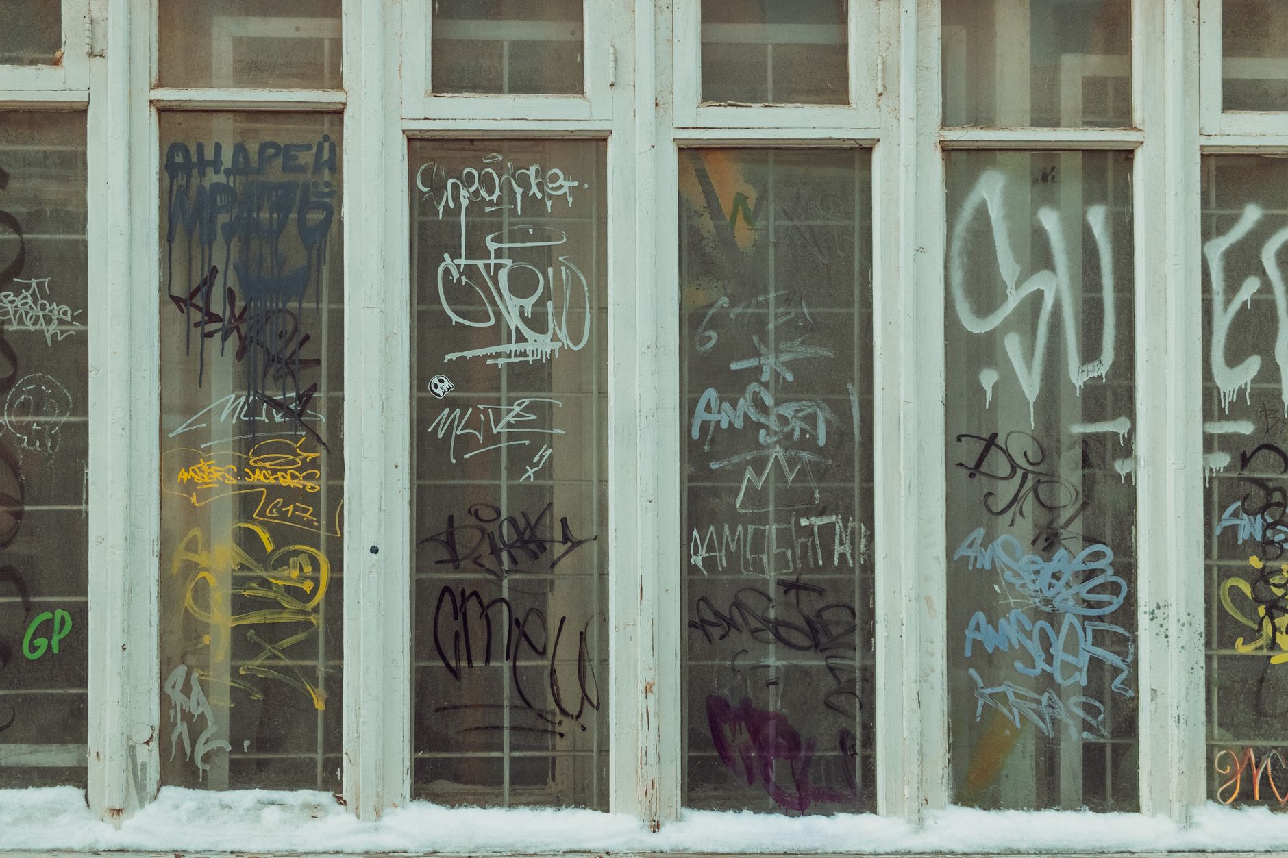 exterior of a large urban grocery store with price tags visible through the plate glass window, early morning light