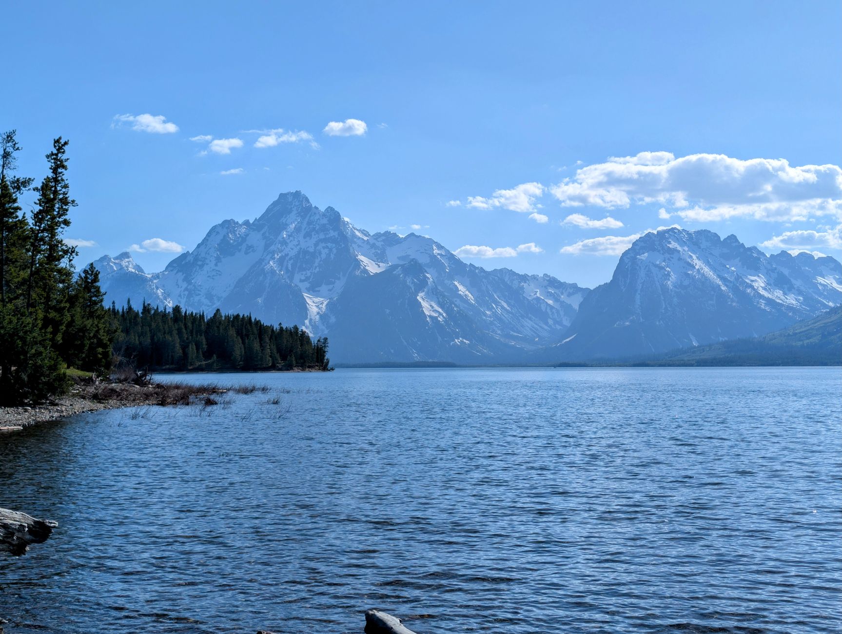 exterior of the Jackson Lake Lodge conference venue at dawn, surrounded by the Grand Teton mountain range with an empty parking area visible in the foreground