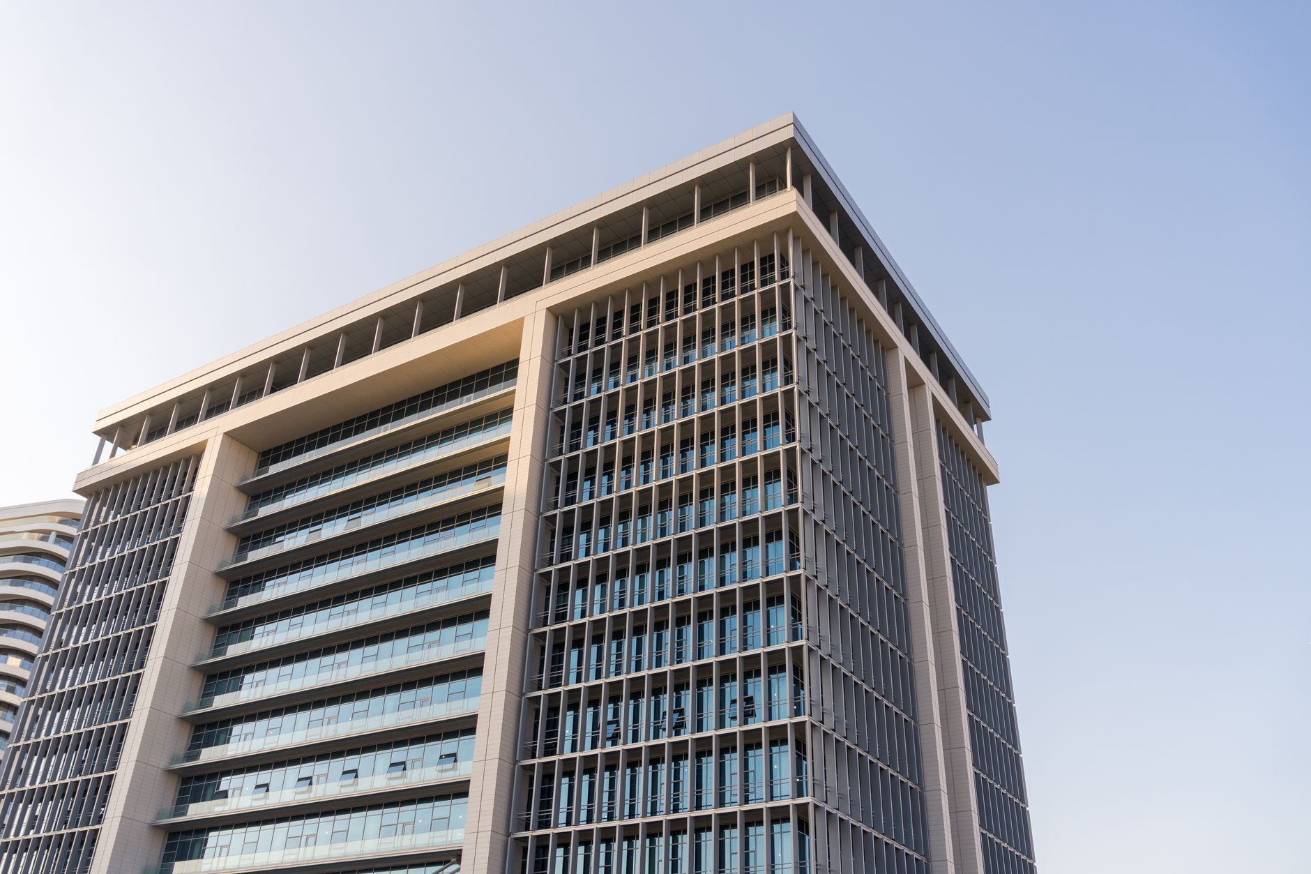 exterior of a modern Tel Aviv office tower in a technology district, glass facade reflecting a clear sky