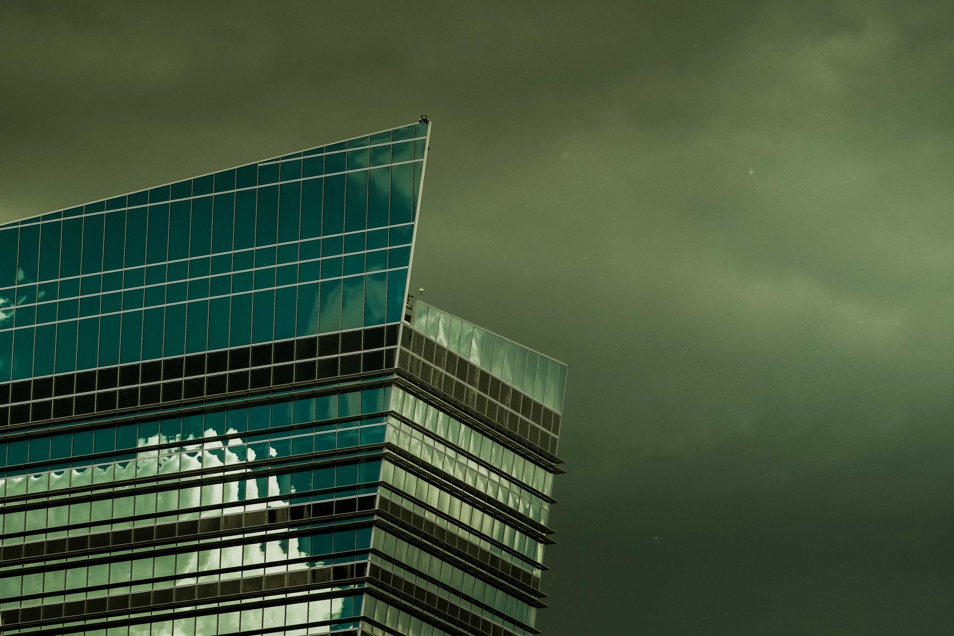 exterior view of a modern Indian stock exchange building at midday, with glass facades reflecting overcast sky