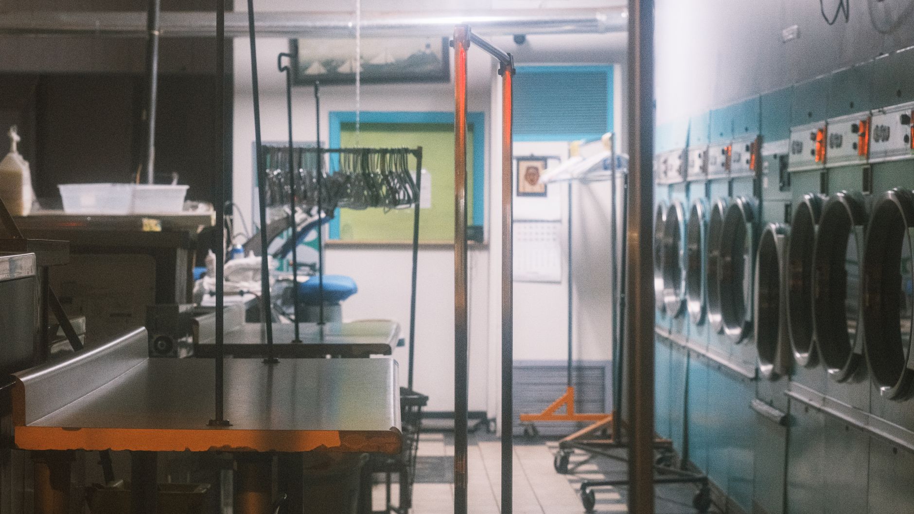 interior of a semiconductor fabrication facility showing rows of cleanroom equipment and wafer processing machines bathed in yellow lighting