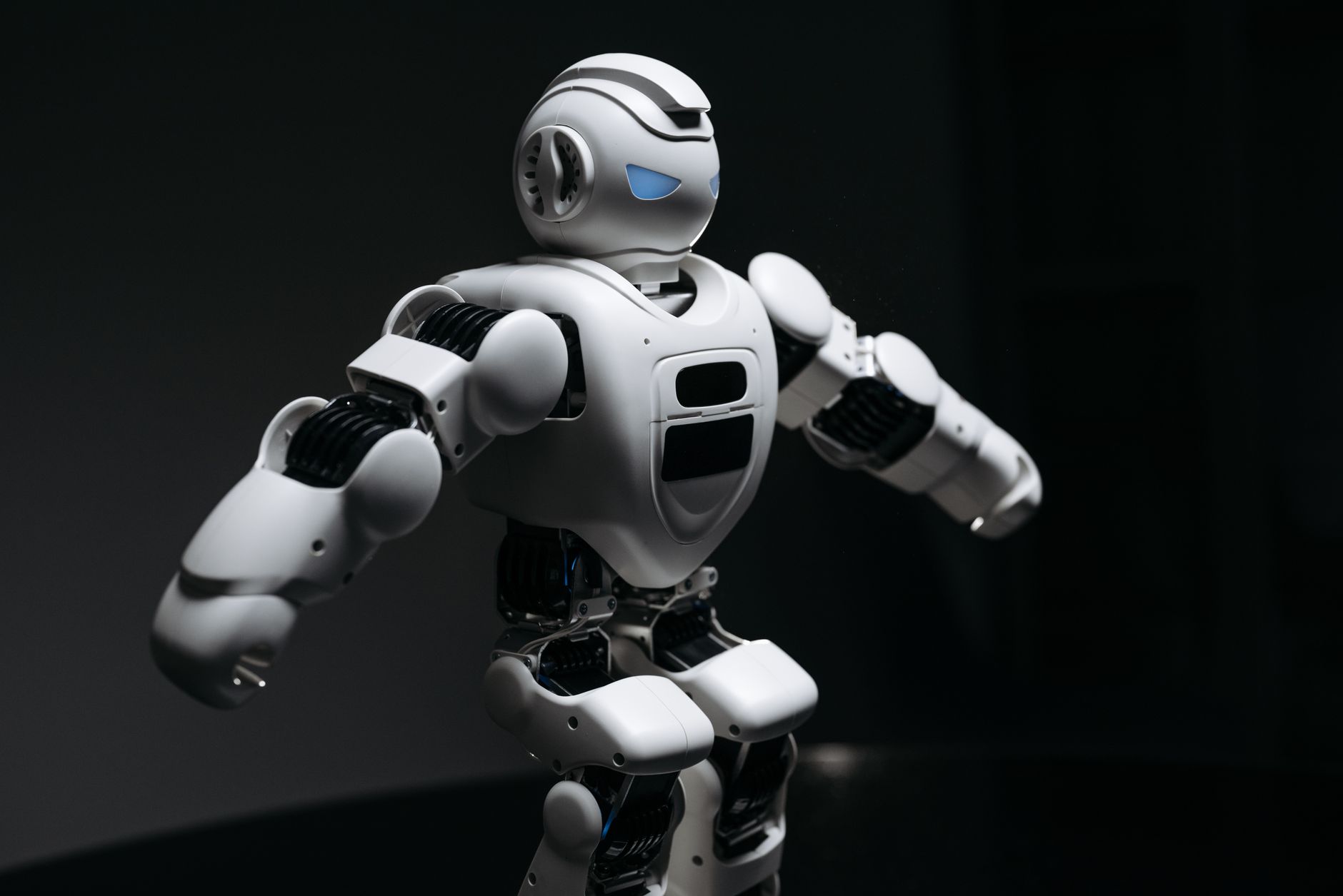 rows of partially assembled humanoid robot chassis on a brightly lit factory floor in a Chinese industrial zone